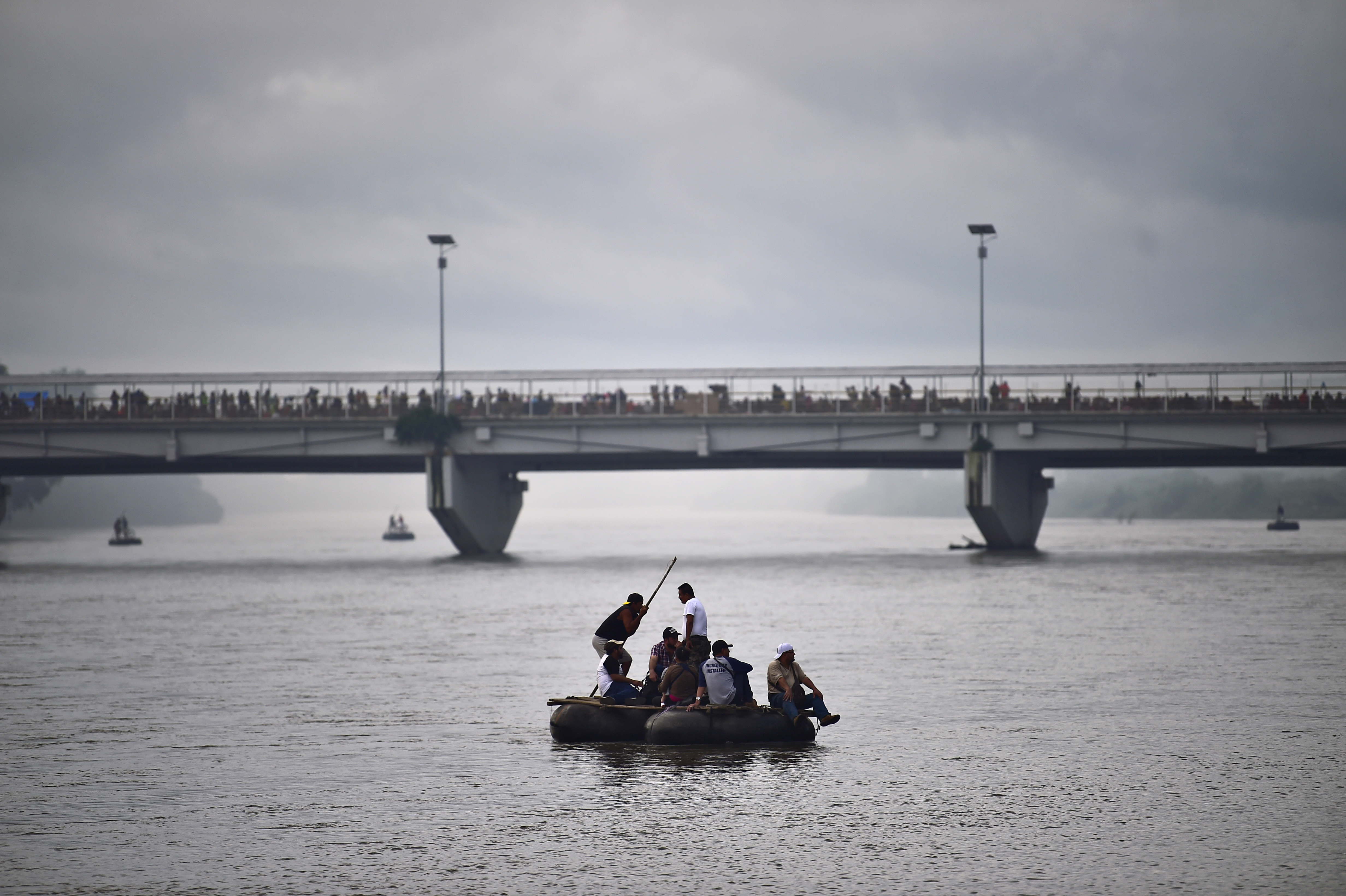 Migrantes hondureños que forman parte de la caravana utilizaron una balsa improvisada para cruzar el río Suchiate, la frontera entre Guatemala y México, el 20 de octubre. Foto: AFP