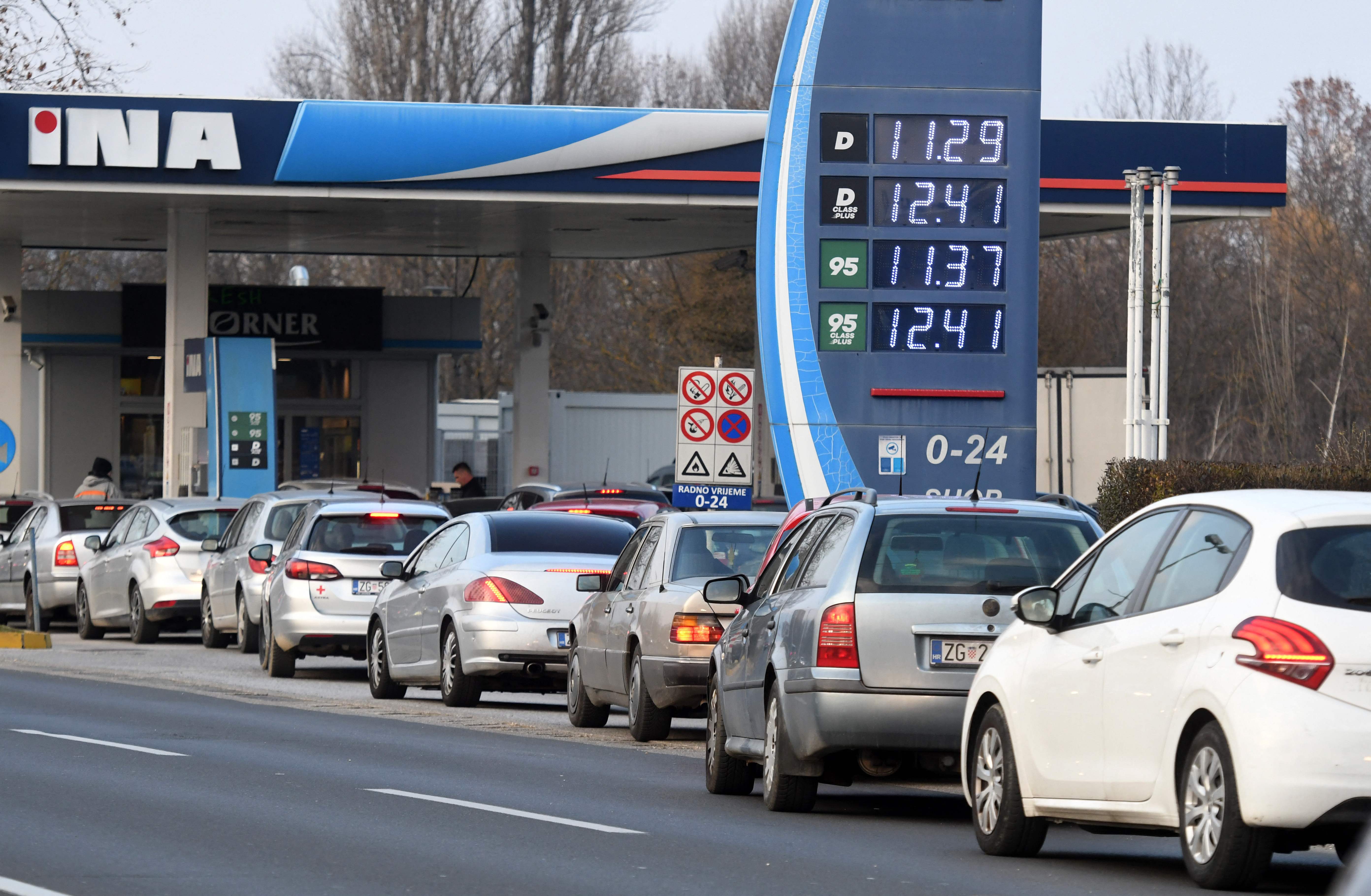 Motorists queue at a petrol station to fill up with fuel before midnight in Zagreb, on March 7, 2022. - Due to the war in Ukraine, fuel prices have started to soar. (Photo by DENIS LOVROVIC / AFP)