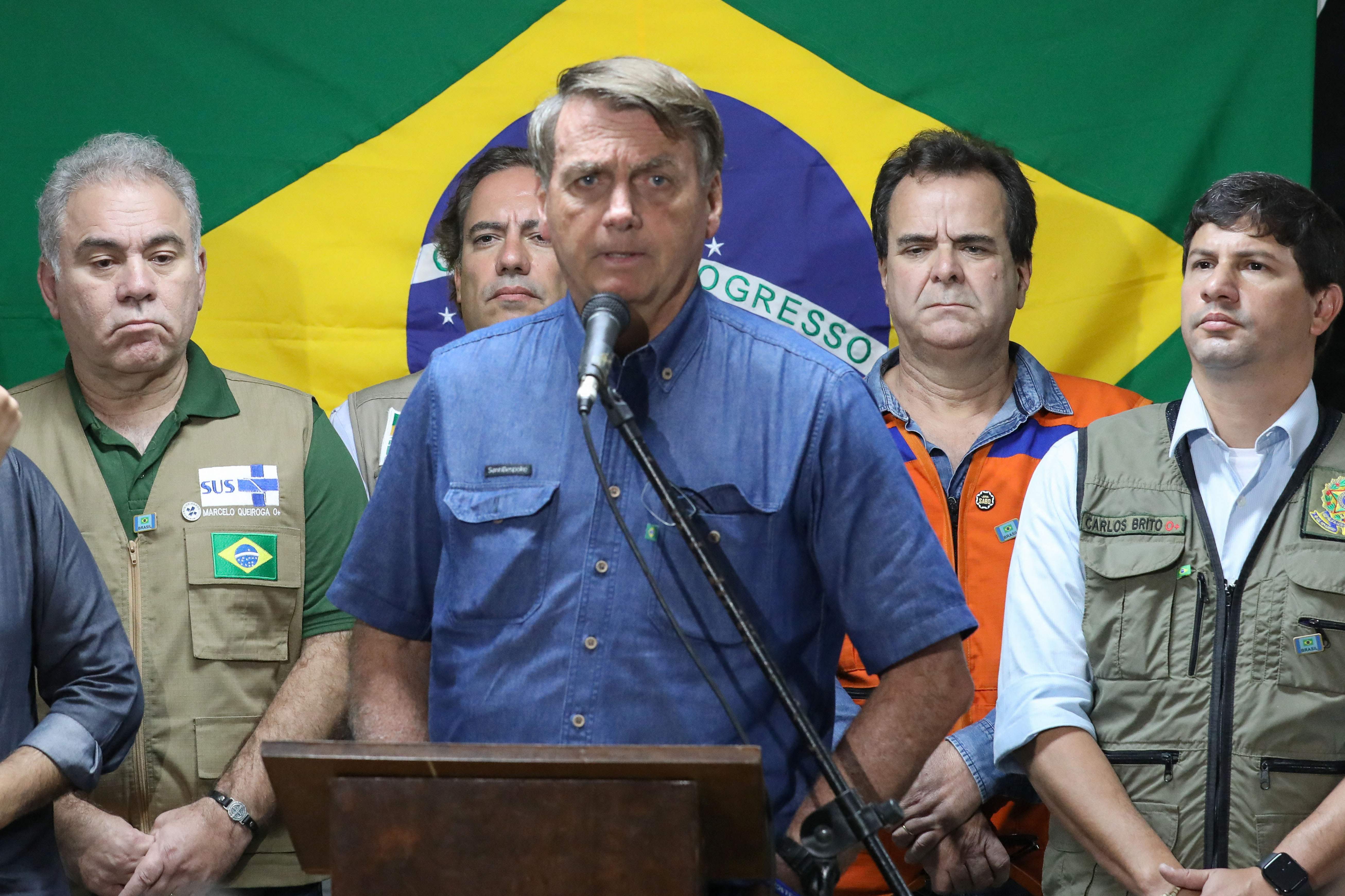Handout picture released by the Brazilian Presidency showing President Jair Bolsonaro making a statement after flying over the areas in Recife, in Pernambuco State, Brazil, which were hit by floods caused by heavy rains in the last week, on May 30, 2022. - According to the latest official data, 91 people died and 5000 were left homeless as a result of the flood and a landslide. President Jair Bolsonaro sent his condolences Monday to the families of 91 people who died in torrential rains in northeastern Brazil, as rescue workers continued a grim search for victims. (Photo by CLAUBER CAETANO / BRAZILIAN PRESIDENCY / AFP) / RESTRICTED TO EDITORIAL USE - MANDATORY CREDIT "AFP PHOTO / BRAZILIAN PRESIDENCY / CLAUBER CAETANO" - NO MARKETING - NO ADVERTISING CAMPAIGNS - DISTRIBUTED AS A SERVICE TO CLIENTS