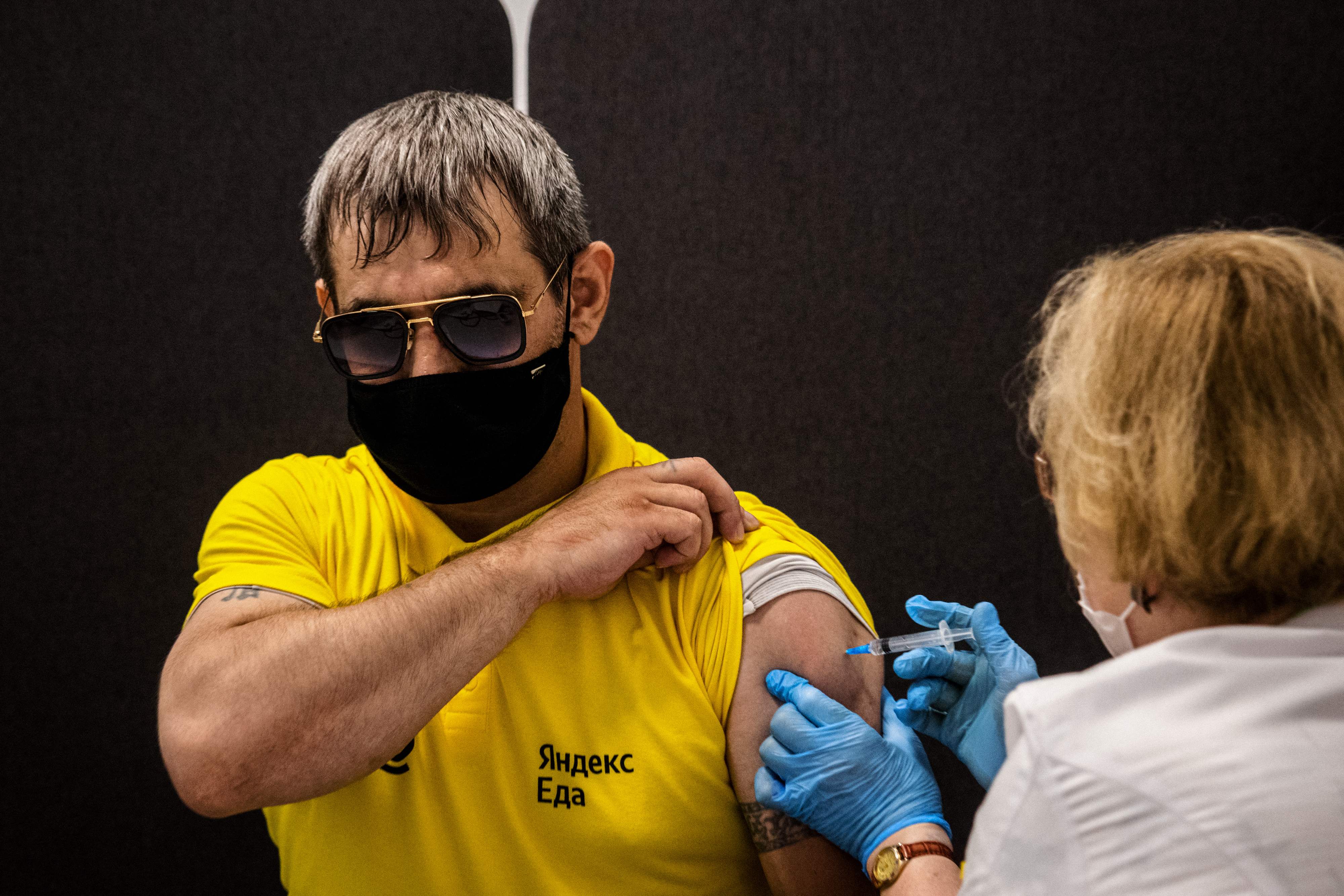 A man receives a dose of Russia's Sputnik V (Gam-COVID-Vac) vaccine a at a vaccination centre for the Yandex Go drivers and couriers in Moscow on June 25, 2021. - Moscow authorities on June 25, 2021, reimposed work-from-home measures, as Russia battles a surging outbreak of the Delta variant worsened by a slow jab drive. The new measures come as Russia has faced an explosion of new cases since mid-June that have been driven by the highly infectious Delta variant first identified India.� (Photo by Dimitar DILKOFF / AFP)