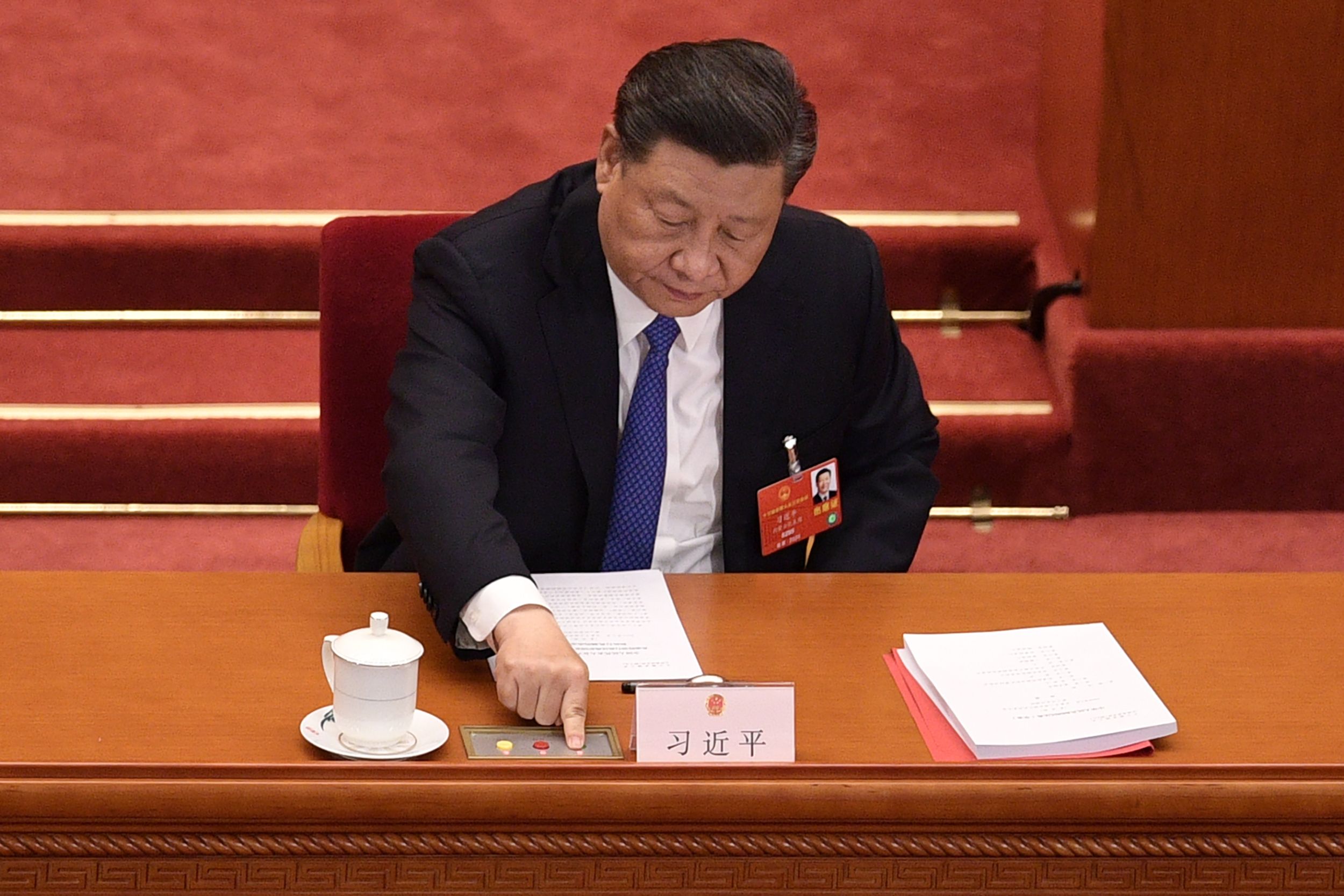 TOPSHOT - Chinese President Xi Jinping votes on a proposal to draft a security law on Hong Kong during the closing session of the National People's Congress at the Great Hall of the People in Beijing on May 28, 2020. - China's rubber-stamp parliament endorsed plans May 28 to impose a national security law on Hong Kong that critics say will destroy the city's autonomy. (Photo by NICOLAS ASFOURI / AFP)