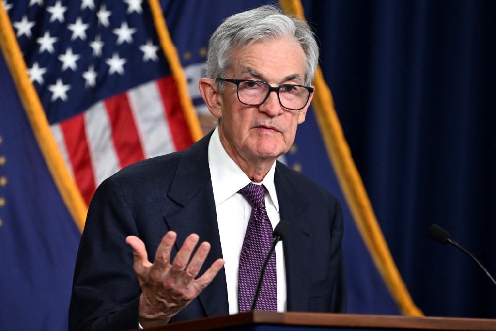 Jerome Powell, presidente de la Reserva Federal, habla en una conferencia de prensa sobre el nuevo recorte de tasas de interés en Estados Unidos, con una bandera estadounidense al fondo.