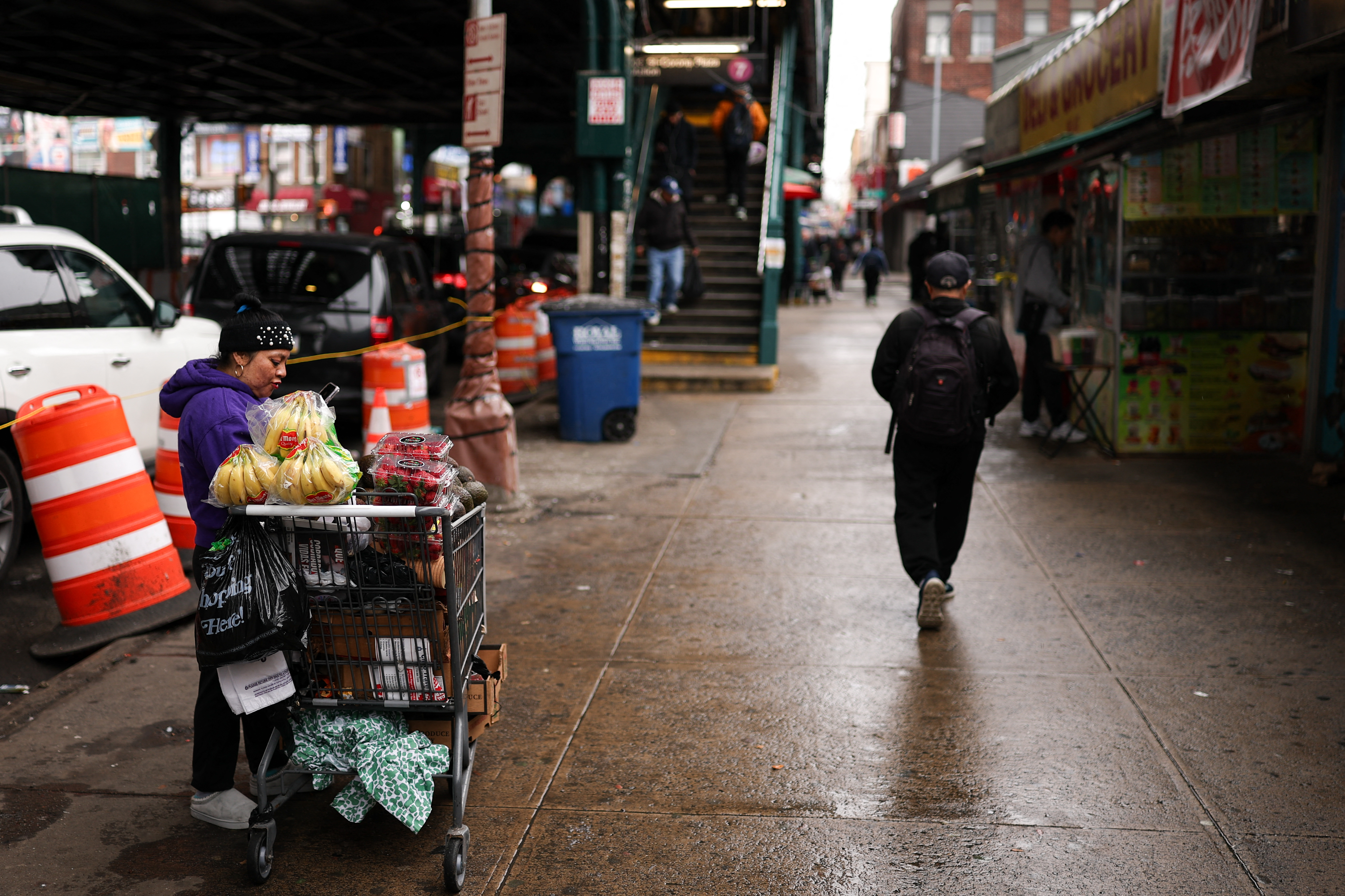 A woman sells fruit on a street in the Corona Plaza area in the Queens borough of New York City on March 20, 2025. A local business owner says that the fear caused by President Donald Trump's immigration policies have left the streets of his largely migrant neigh