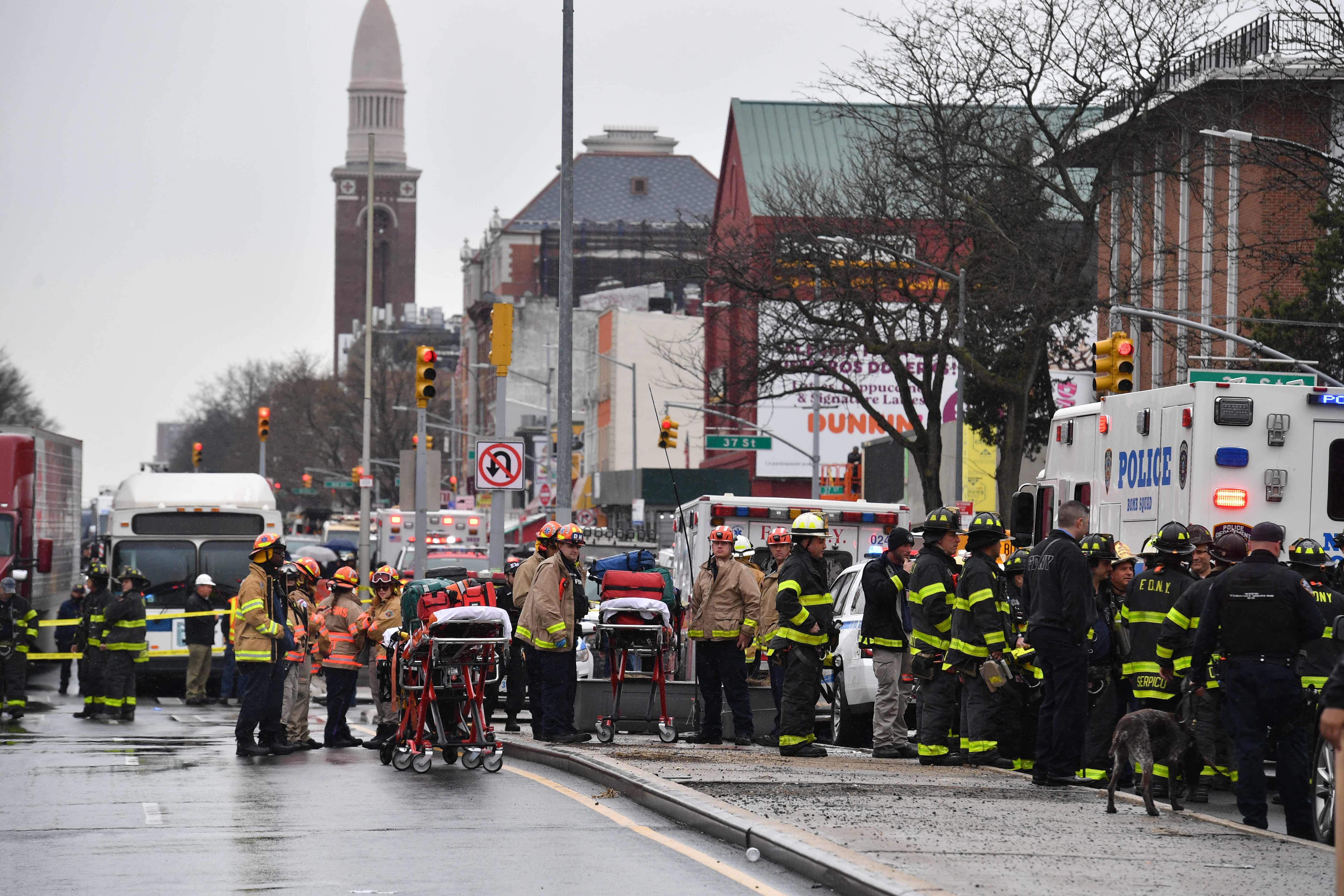 Members of the New York Police Department and emergency personel crowd the streets near a subway station in the New York City borough of Brooklyn on April 12, 2022. - At least 13 people have been injured during a shooting incident, authorities said. The city's fire department gave the injuries toll, with ABC News quoting police sources as saying at least five people had been shot. (Photo by ANGELA WEISS / AFP)