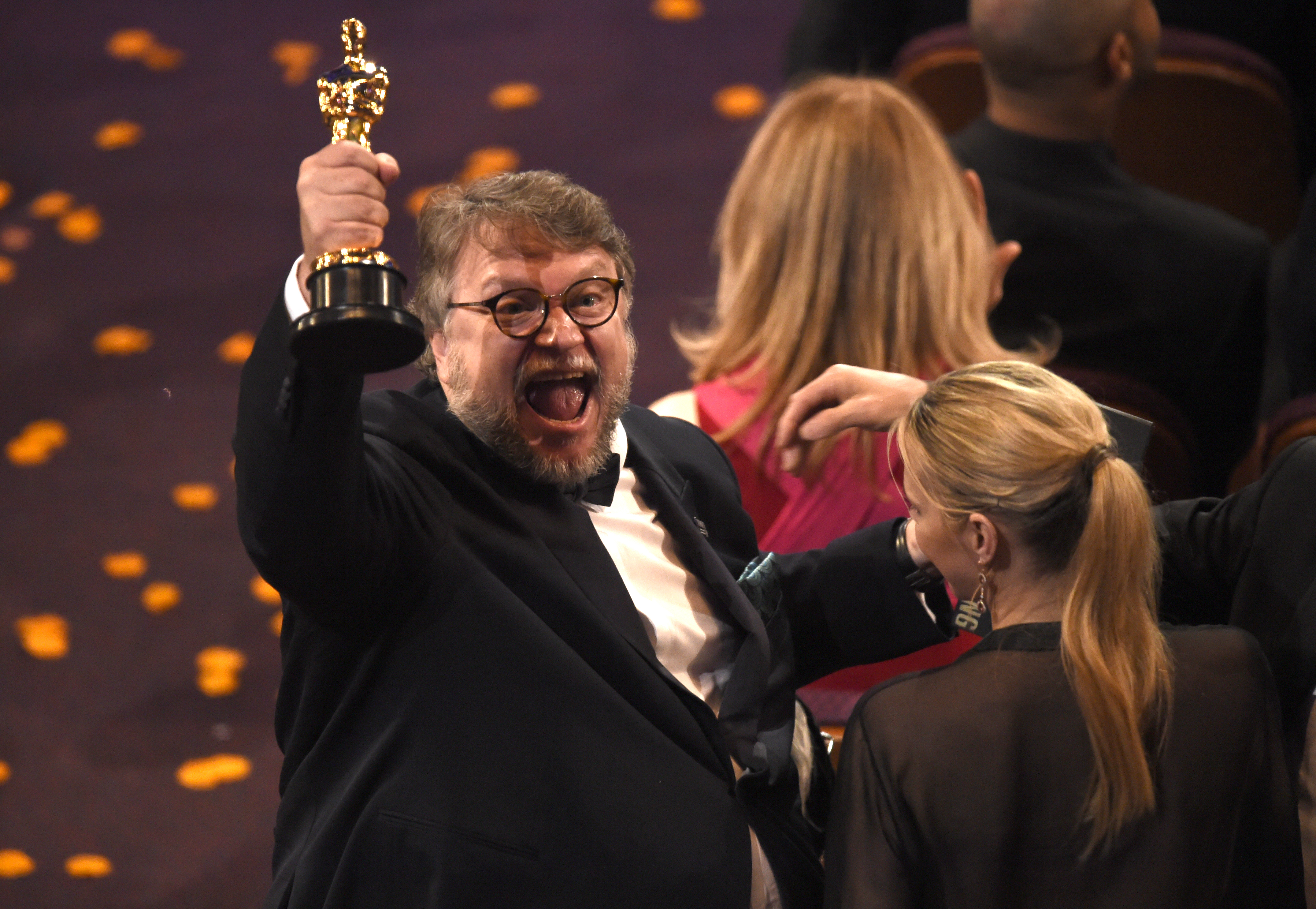 Guillermo del Toro le muestra a la audiencia que asistió a los premis Óscar su estatuilla como mejor director por "The Shape of Water". Foto: AP.