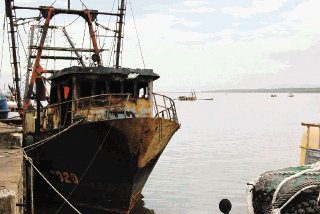13/05/09 hora 11 a.m. Puntarenas. Pescadores, muelleros y embarcaciones quemadas en un incendio que ocurrió el pasado martes santo en esta ciudad del Pacífico. El Manolete en primer plano y al fondo se observa el Bucanero y a la derecha al fondo dos embarcaciones más que también se encuentran semi hundidas en el estero. /Ronny Soto S.