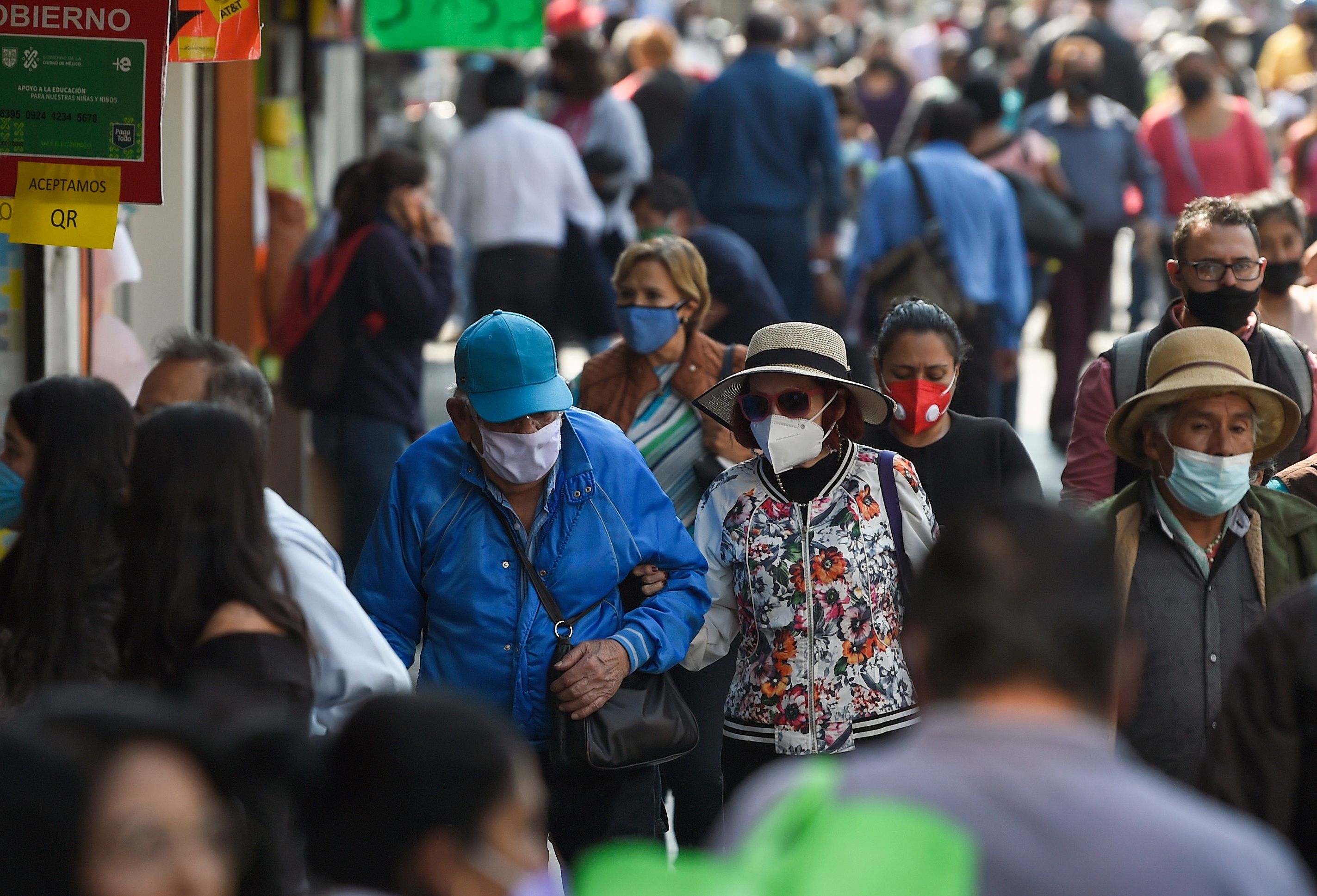 People wearing face masks walk at downtown streets in the start of the Christmas season in Mexico City on December 1, 2020, amid the COVID-19 coronavirus pandemic. - Mexico City's government reported that the orange alert is still on due to the high number of COVID-19 infections that have been registered in the city. (Photo by ALFREDO ESTRELLA / AFP)