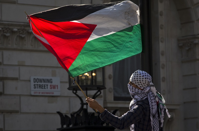 Un manifestante agitaba el miércoles una bandera de Palestina, frente a la sede del Gobierno británico, en Londres, para protestar contra una visita del primer ministro israelí, Benjamín Netanyahu.
