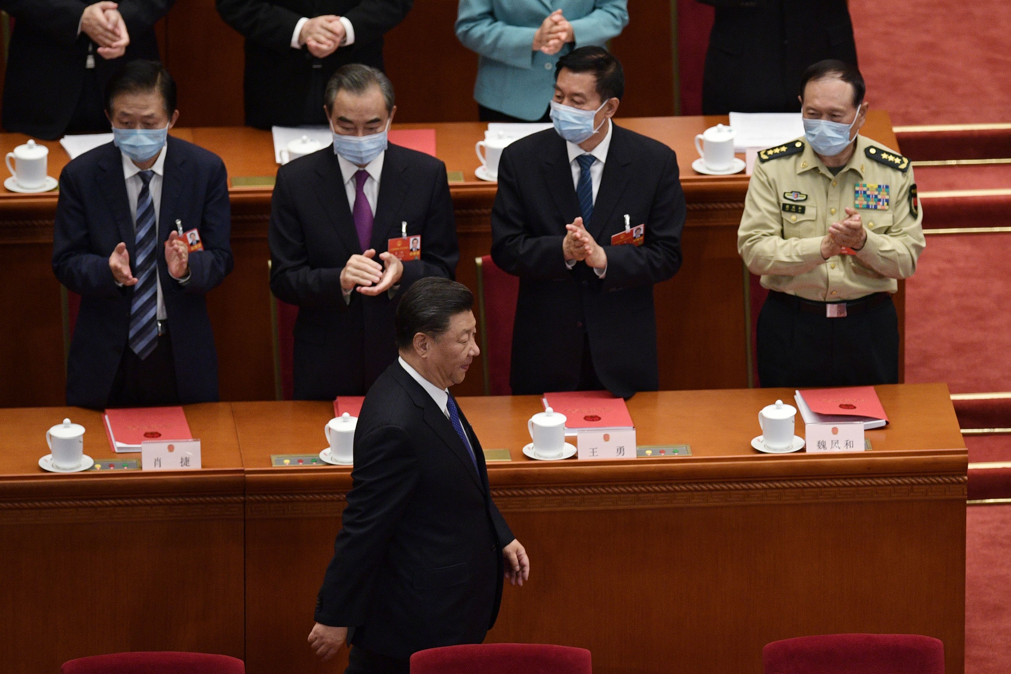 TOPSHOT - Chinese President Xi Jinping is applauded by, from left, State Councilor Xiao Jie, Foreign Minister Wang YiState Councilor Wang Yong, and Defence Minister Wei Fenghe, as he arrives for the closing session of the National People's Congress at the Great Hall of the People in Beijing on May 28, 2020. - China's rubber-stamp parliament endorsed plans May 28 to impose a national security law on Hong Kong that critics say will destroy the city's autonomy. (Photo by NICOLAS ASFOURI / AFP)