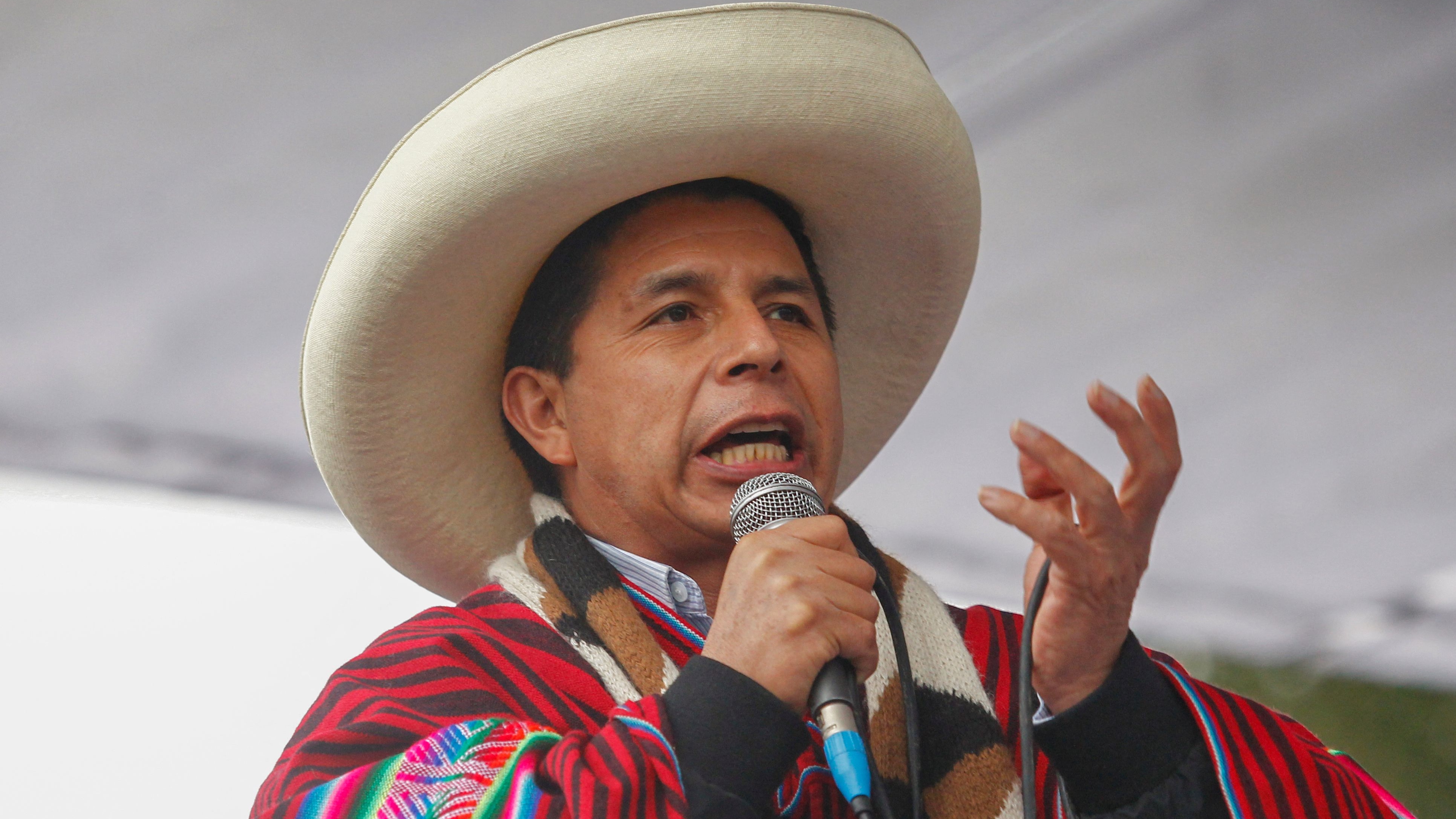 , dressed in typical Andean attire, speaks during a massive rally calling for political and economic stability in Juliaca, Puno region, Peru, on December 7, 2021, as the country�s opposition-majority parliament discusses whether or not to hold an impeachment trial for the leftist leader. - Peru's Congress, controlled by the right-wing opposition, began a plenary session on Tuesday to decide whether to open a political impeachment trial for left-wing president Pedro Castillo. The session must conclude with the decisive vote. (Photo by Carlos MAMANI / AFP)