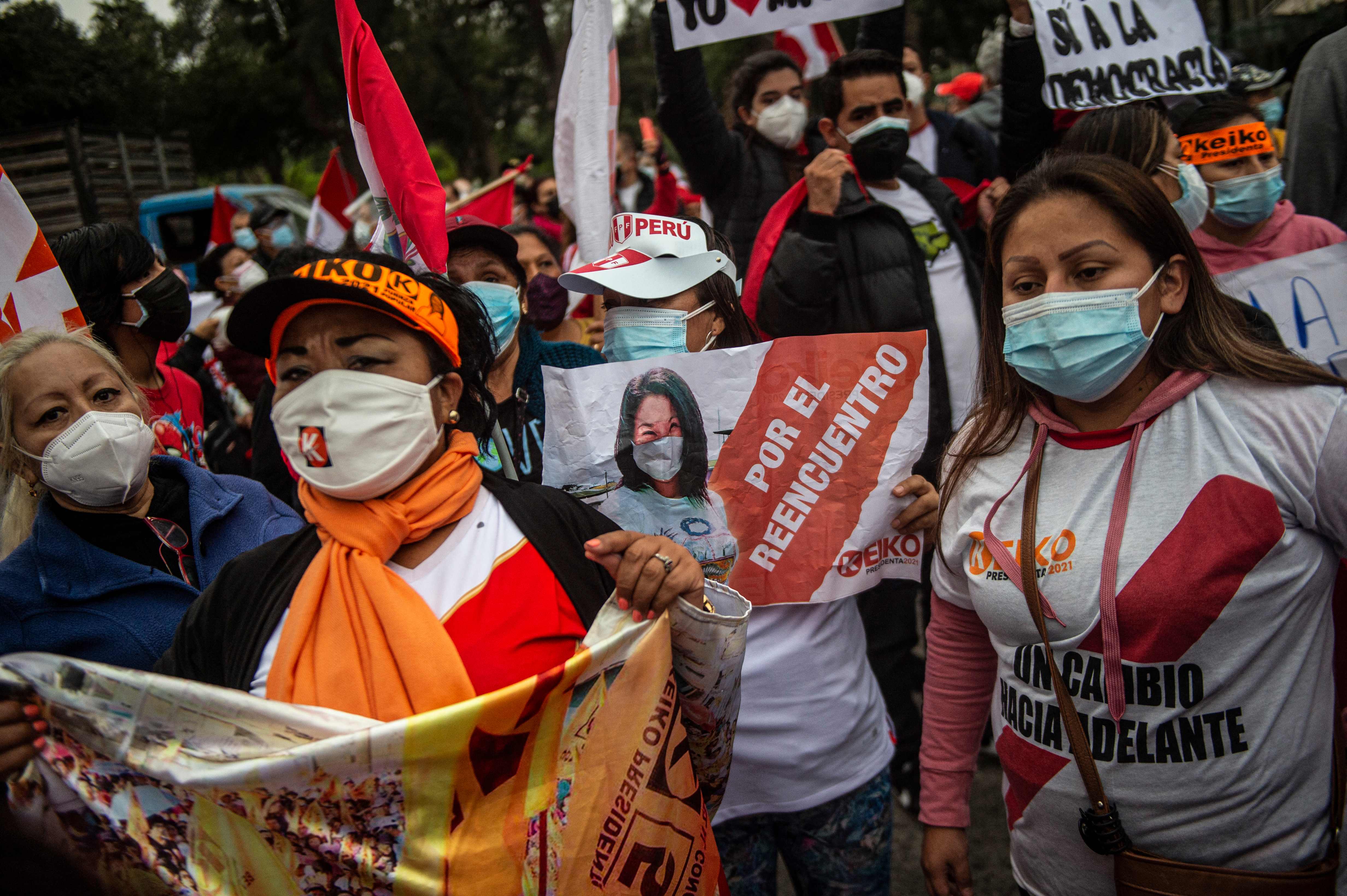 TOPSHOT - Supporters of the Peruvian candidate for Fuerza Popular party, Keiko Fujimori, protest in front of the National Organism of Electoral Processes (ONPE) building in Lima, on June 09, 2021. - Far-left trade unionist Pedro Castillo has cast himself as the winner of Peru's presidential election, thanking foreign nations for "victory" messages even as election officials said Wednesday the race was not over. With over 98 percent of votes cast in Sunday's presidential poll counted by Wednesday morning, Castillo retained a leading score of 50.2 percent over rightwing populist rival Keiko Fujimori's 49.7 percent. (Photo by Ernesto BENAVIDES / AFP)