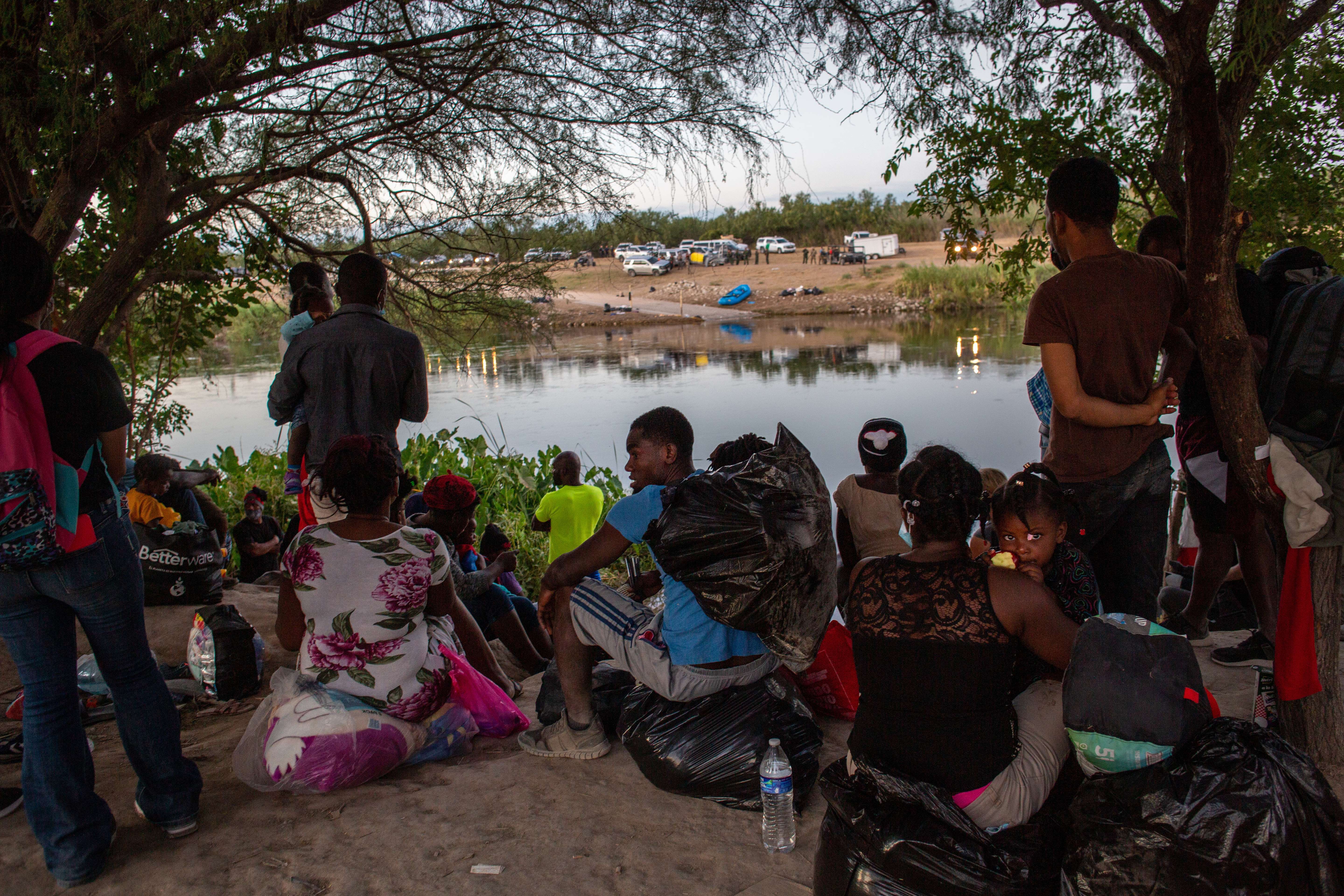 CIUDAD ACUNA, MEXICO - SEPTEMBER 23: Haitian immigrants wait to cross the Rio Grande into Del Rio, Texas on September 23, 2021 from Ciudad Acuna, Mexico. On the U.S. side of the bridge (R), up to 14,000 immigrants had been encamped in squalid conditions. U.S. immigration officials say they have mostly cleared the camp of immigrants, deporting some and releasing others to pursue asylum claims in the United States. John Moore/Getty Images/AFP
== FOR NEWSPAPERS, INTERNET, TELCOS & TELEVISION USE ONLY ==