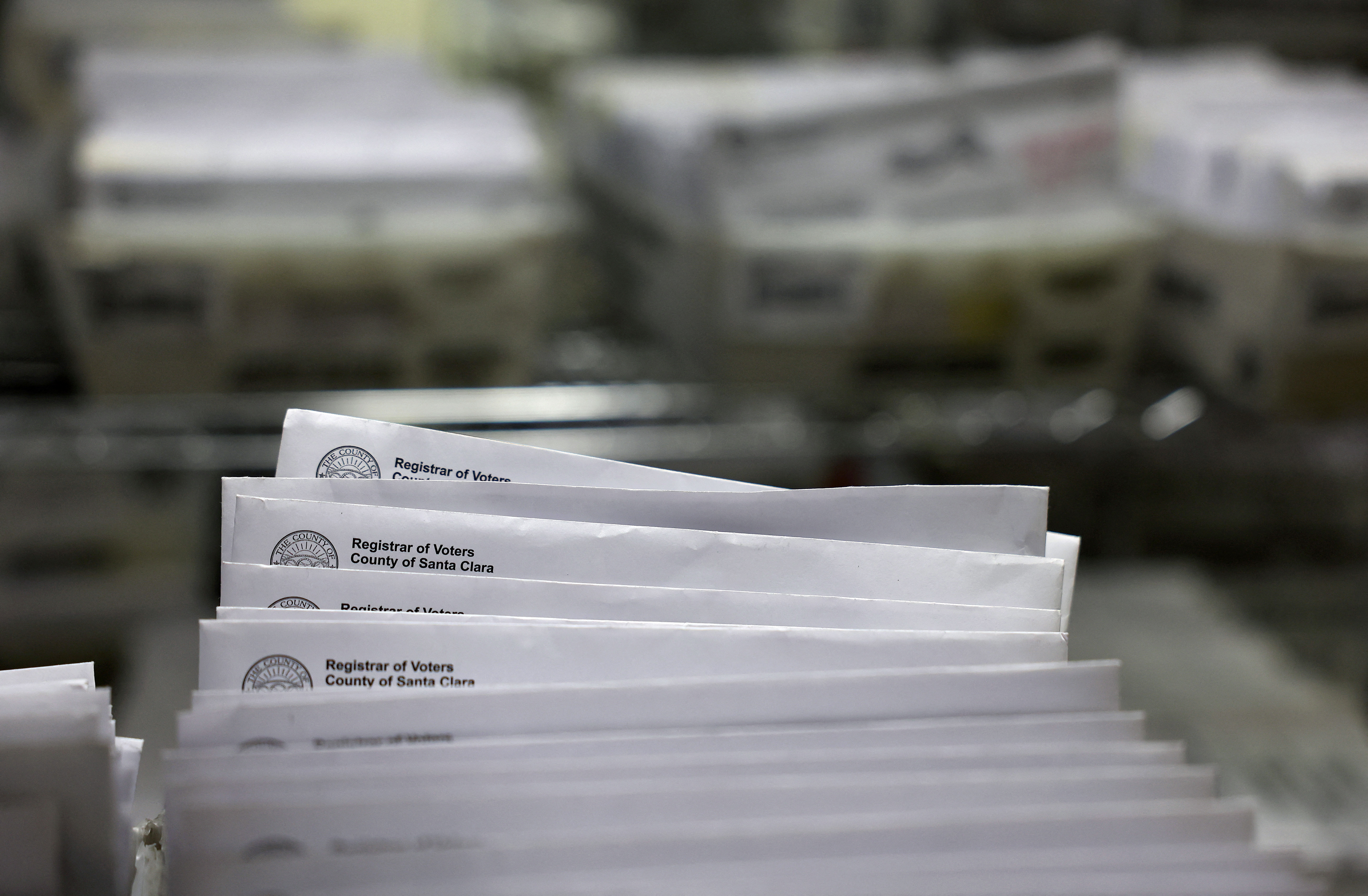 Las bandejas con boletas electorales enviadas por correo se apilan en la oficina del registro de votantes del condado de Santa Clara el 21 de octubre en San José, California.