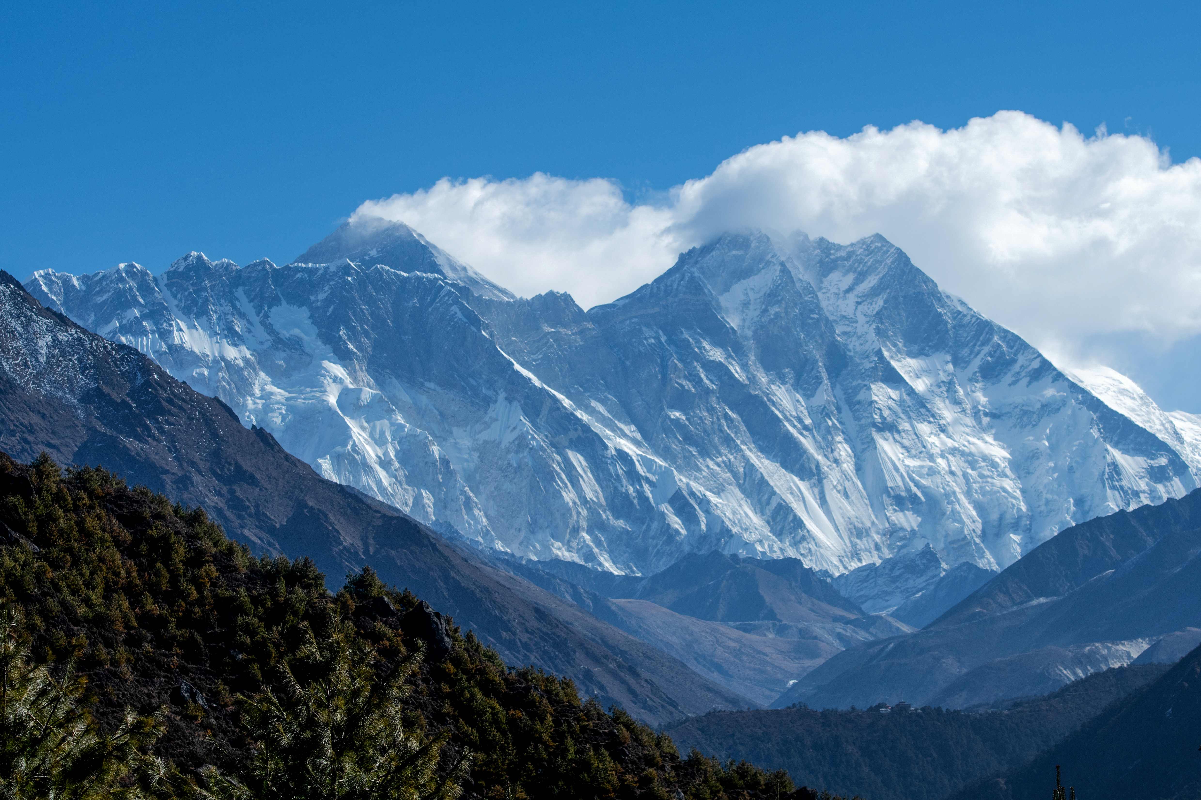 (FILES) In this file photo taken on March 26, 2020, the Himalayan Mount Everest (C-L) and other mounts ranges are pictured from Namche Bazar in the Everest region, some 140 kms northeast of Kathmandu. - The highest point on Earth got a bit higher on December 8 as China and Nepal finally agreed on a precise elevation for Mount Everest after decades of debate. The agreed height unveiled at a joint news conference in Kathmandu of 8,848.86 metres (29,031 feet) was 86 centimetres (2.8 feet) higher than the measurement previously recognised by Nepal, and more than four metres above China's official figure. (Photo by PRAKASH MATHEMA / AFP)