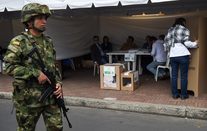 Un soldado monta guardia en una mesa de votación en Bogotá durante las elecciones parlamentarias en Colombia. Foto: AFP.