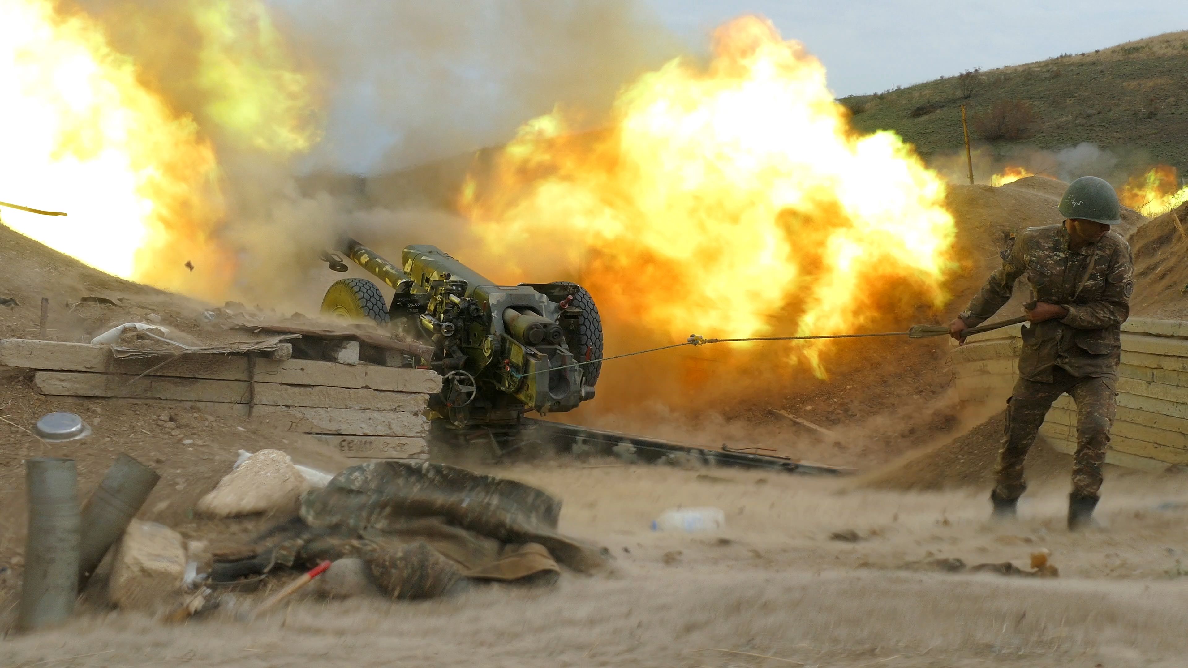 A serviceman of Karabakh's Defence Army fires an artillery piece towards Azeri positions during the ongoing fighting over the breakaway Nagorno-Karabakh region on October 4, 2020. (Photo by Handout / RazmInfo/Armenian Defence Ministry / AFP) / RESTRICTED TO EDITORIAL USE - MANDATORY CREDIT "AFP PHOTO / RazmInfo/Armenian Defence Ministry / handout " - NO MARKETING - NO ADVERTISING CAMPAIGNS - DISTRIBUTED AS A SERVICE TO CLIENTS