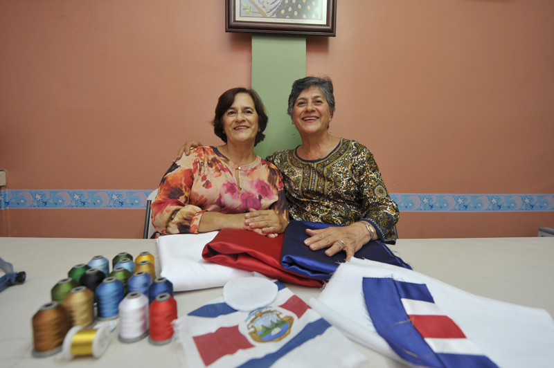 Las hermanas María Elena y Rosario Camacho con las telas e hilos que usaron, en Santo Domingo de Heredia, para bordar la banda presidencial de Luis Guillermo Solís.
