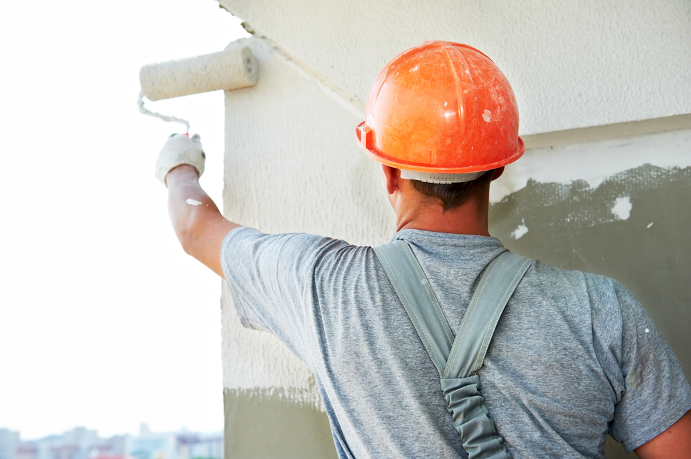 El trabajador aplicando pintura impermeabilizante a la pared del