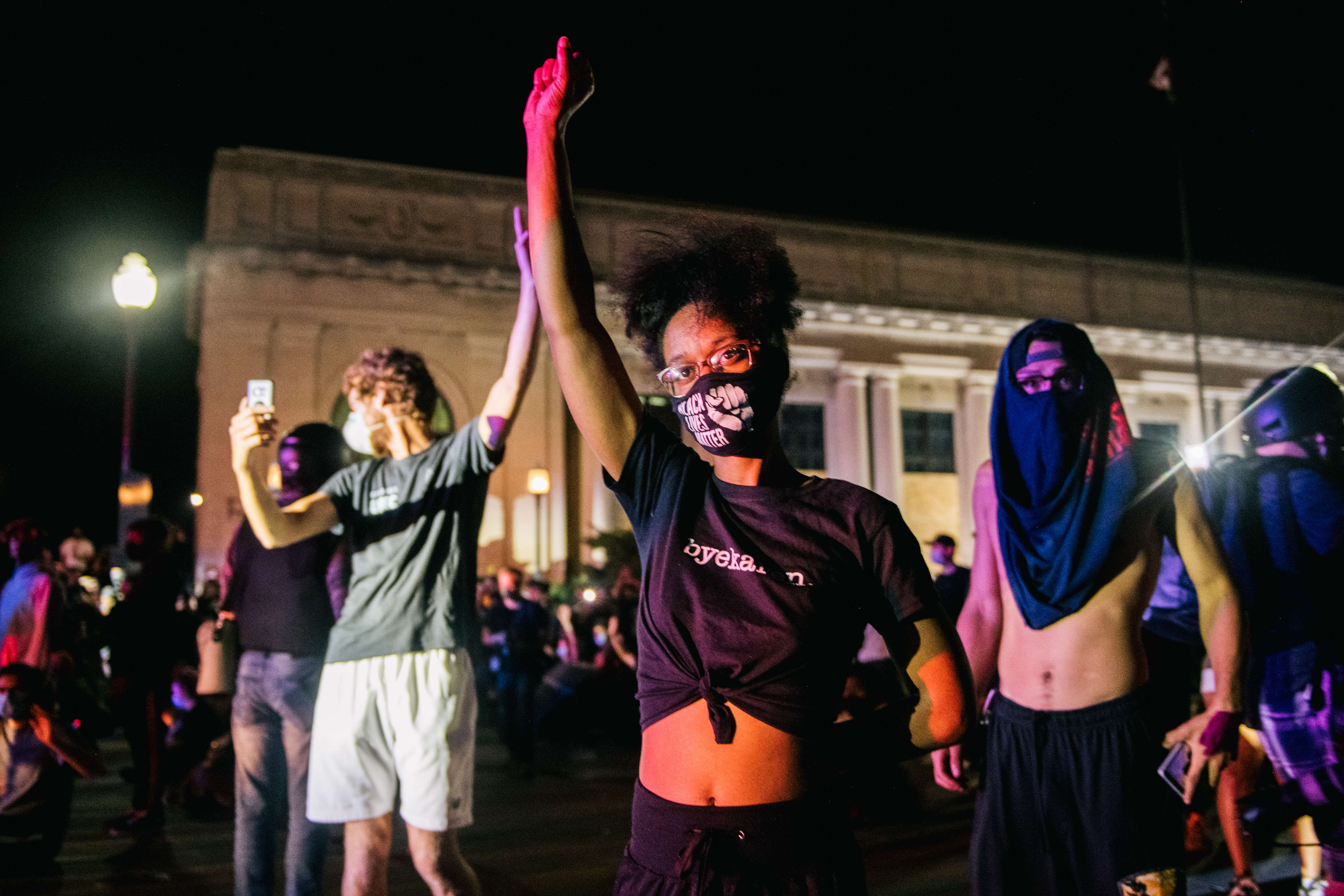 KENOSHA, WI - AUGUST 25: Demonstrators raise their fist in the air, in front of law enforcement, on August 25, 2020 in Kenosha, Wisconsin. As the city declared a state of emergency curfew, a third night of civil unrest occurred after the shooting of Jacob Blake, 29, on August 23. Video shot of the incident appears to show Blake shot multiple times in the back by Wisconsin police officers while attempting to enter the drivers side of a vehicle. The 29-year-old Blake was undergoing surgery for a severed spinal cord, shattered vertebrae and severe damage to organs, according to the family attorneys in published accounts. Brandon Bell/Getty Images/AFP
== FOR NEWSPAPERS, INTERNET, TELCOS & TELEVISION USE ONLY ==