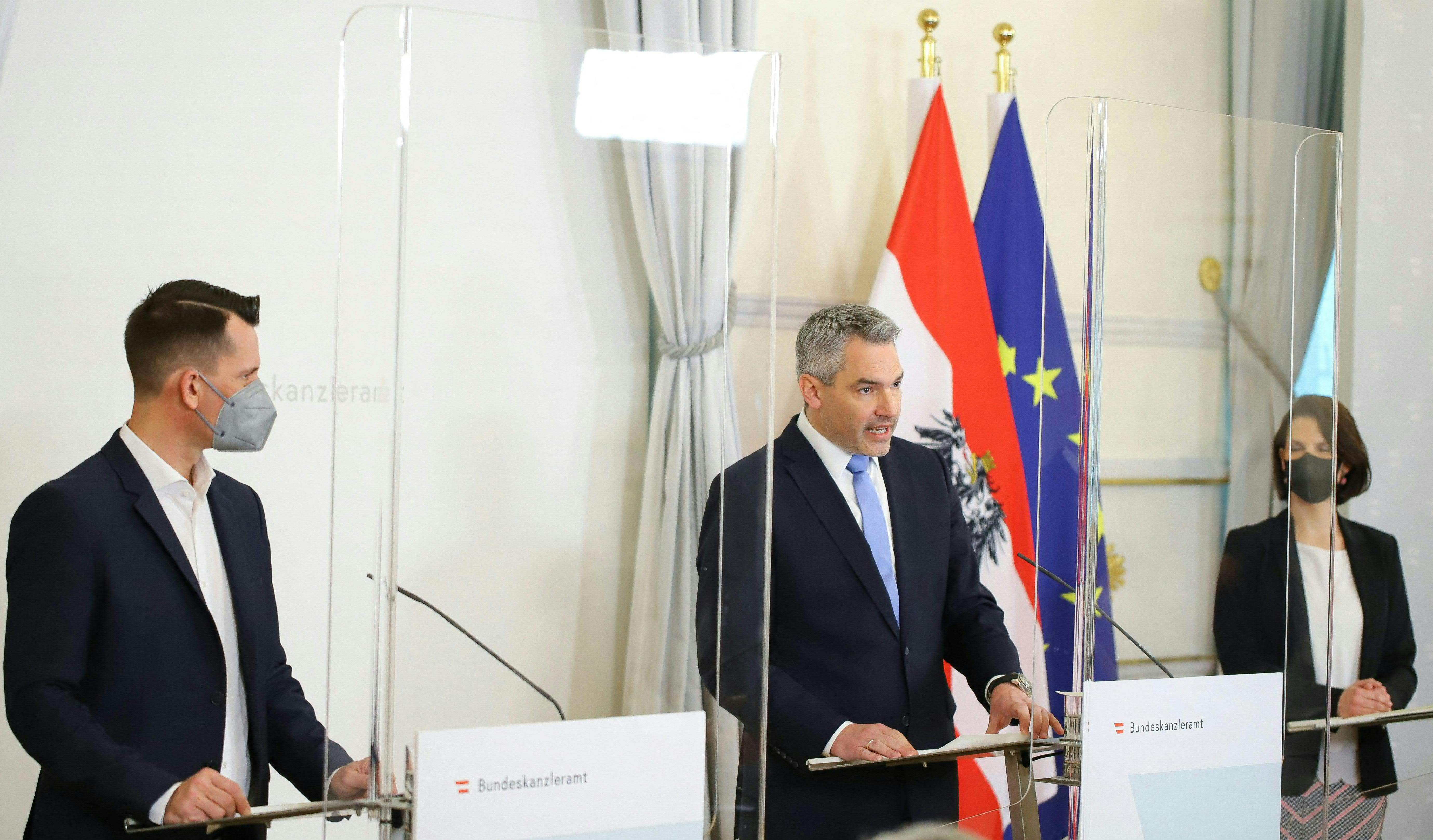 (LtoR) Austrian Minister for Health Wolfgang M�ckstein, Austrian Chancellor Karl Nehammer and Austrian Minister for the Constitution Karoline Edtstadler address a press conference at the Chancellery in Vienna on January 16, 2022, to present a mandatory vaccination bill that should enter into force at the start of February. (Photo by TOBIAS STEINMAURER / APA / AFP) / Austria OUT