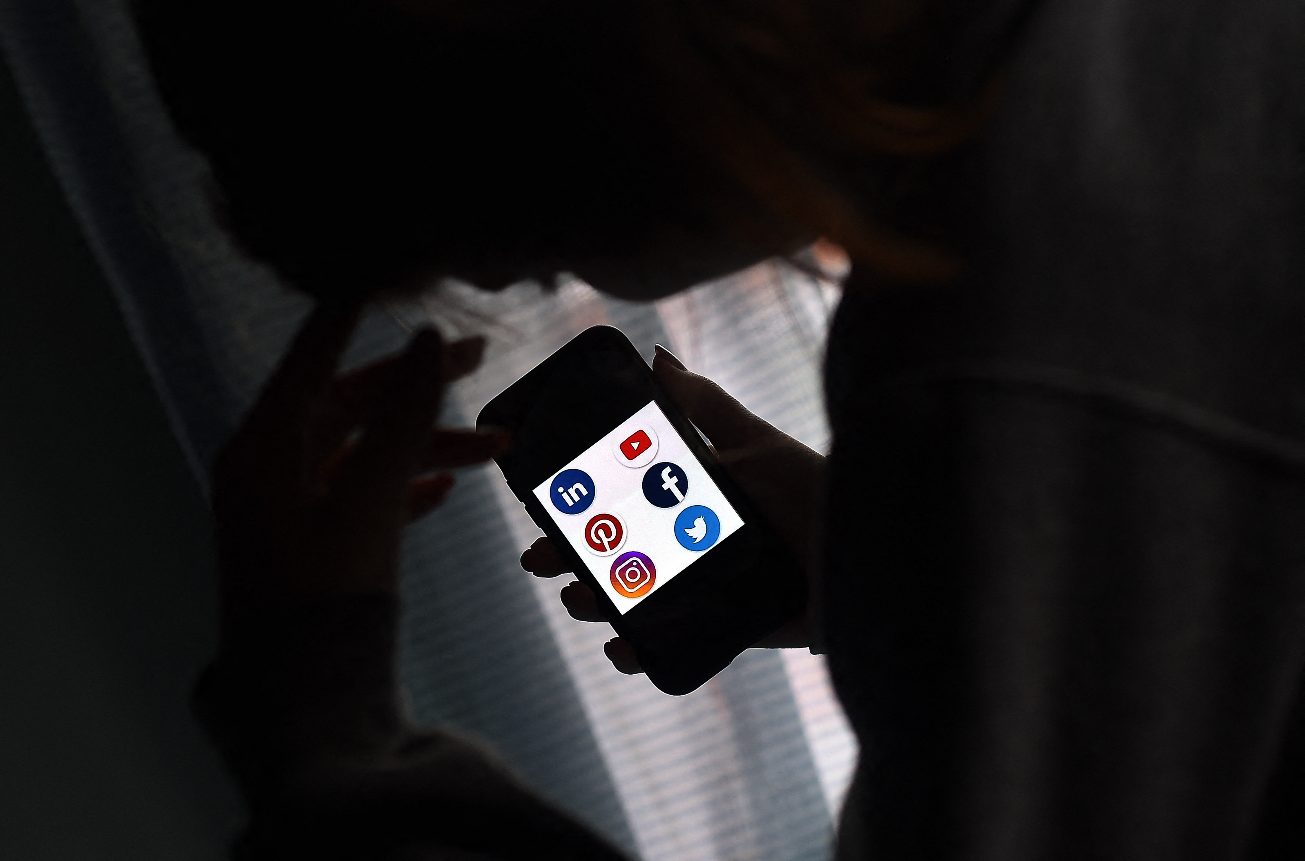 (FILES) This file photo illustration picture shows social media applications logos from Linkedin, YouTube, Pinterest, Facebook, Instagram and Twitter displayed on a smartphone in Arlington, Virginia on May 28, 2020. - A federal judge has blocked a Florida law which sought to prevent social media firms from taking down content from political candidates, saying the measure was "wholly at odds with accepted constitutional principles" of free speech. Judge Robert Hinkle, in a ruling late June 30, 2021, said the law passed by the Florida legislature and signed by Governor Ron DeSantis distorted the idea of free-speech protections by placing restrictions on certain social media platforms for moderating content. (Photo by Olivier DOULIERY / AFP)