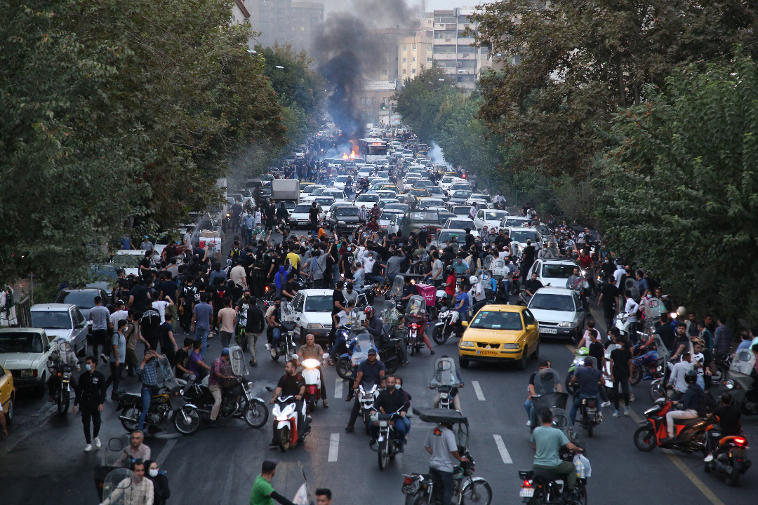 TOPSHOT - A picture obtained by AFP outside Iran on September 21, 2022, shows Iranian demonstrators taking to the streets of the capital Tehran during a protest for Mahsa Amini, days after she died in police custody. - Protests spread to 15 cities across Iran overnight over the death of the young woman Mahsa Amini after her arrest by the country's morality police, state media reported today.In the fifth night of street rallies, police used tear gas and made arrests to disperse crowds of up to 1,000 people, the official IRNA news agency said. (Photo by AFP)