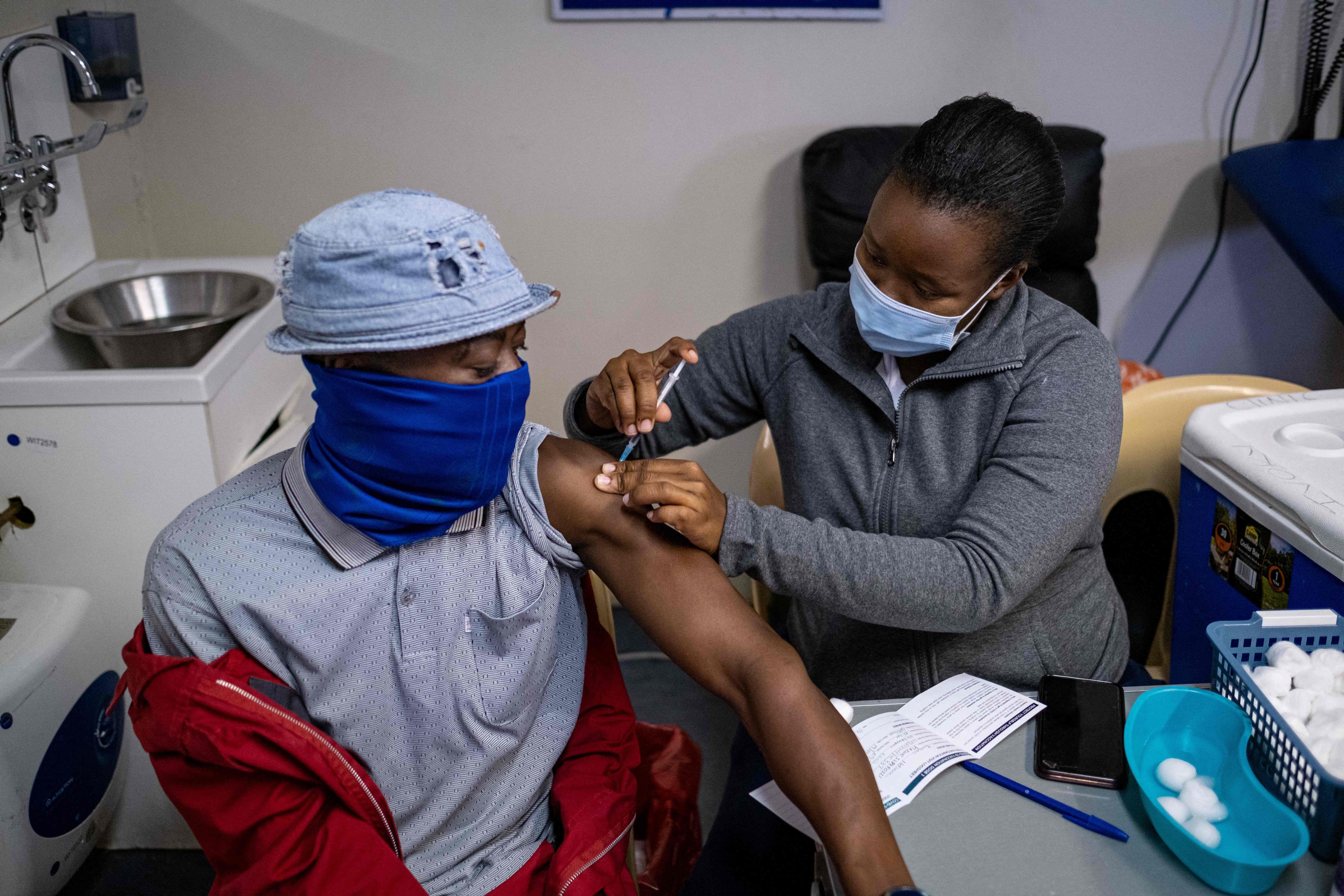 A patient gets vaccinated against COVID-19 at the Witkoppen clinic in Johannesburg on December 8, 2021. - Anti-Covid vaccines may lose effectiveness against Omicron, but one more dose could remedy this. Initial elements, notably given by the Pfizer laboratory, shed light on the capacity of the new variant to resist vaccination. Omicron is "probably not sufficiently neutralized after two doses", admitted Wednesday the groups Pfizer and BioNTech, whose anti-Covid vaccine is given in two injections. (Photo by EMMANUEL CROSET / AFP)