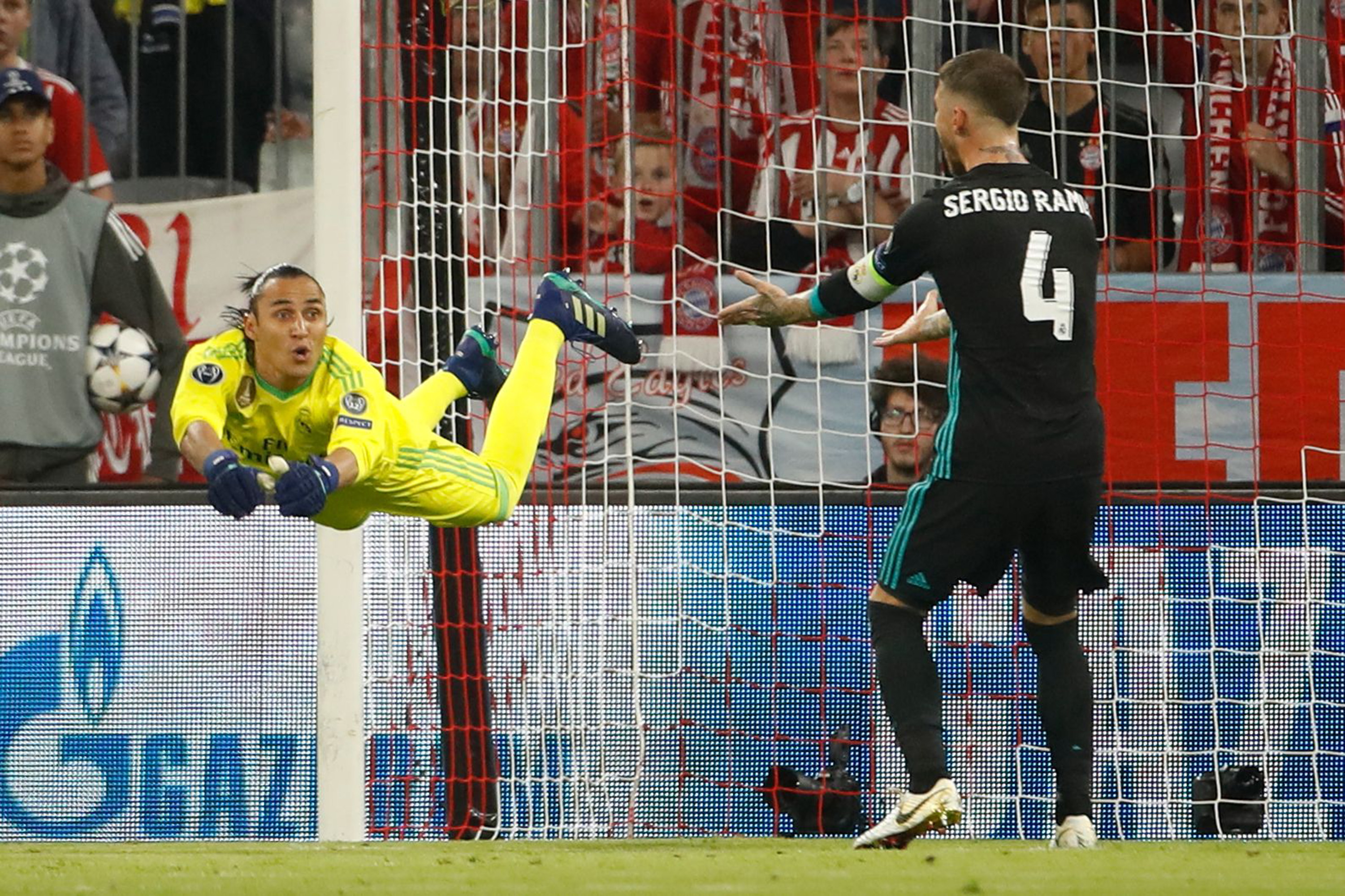 Real Madrid's Costa Rican goalkeeper Keylor Navas (L) dives for the ball next to Real Madrid's Spanish defender Sergio Ramos during the UEFA Champions League semi-final first-leg football match FC Bayern Munich v Real Madrid CF in Munich, southern Germany on April 25, 2018. / AFP PHOTO / Odd ANDERSEN