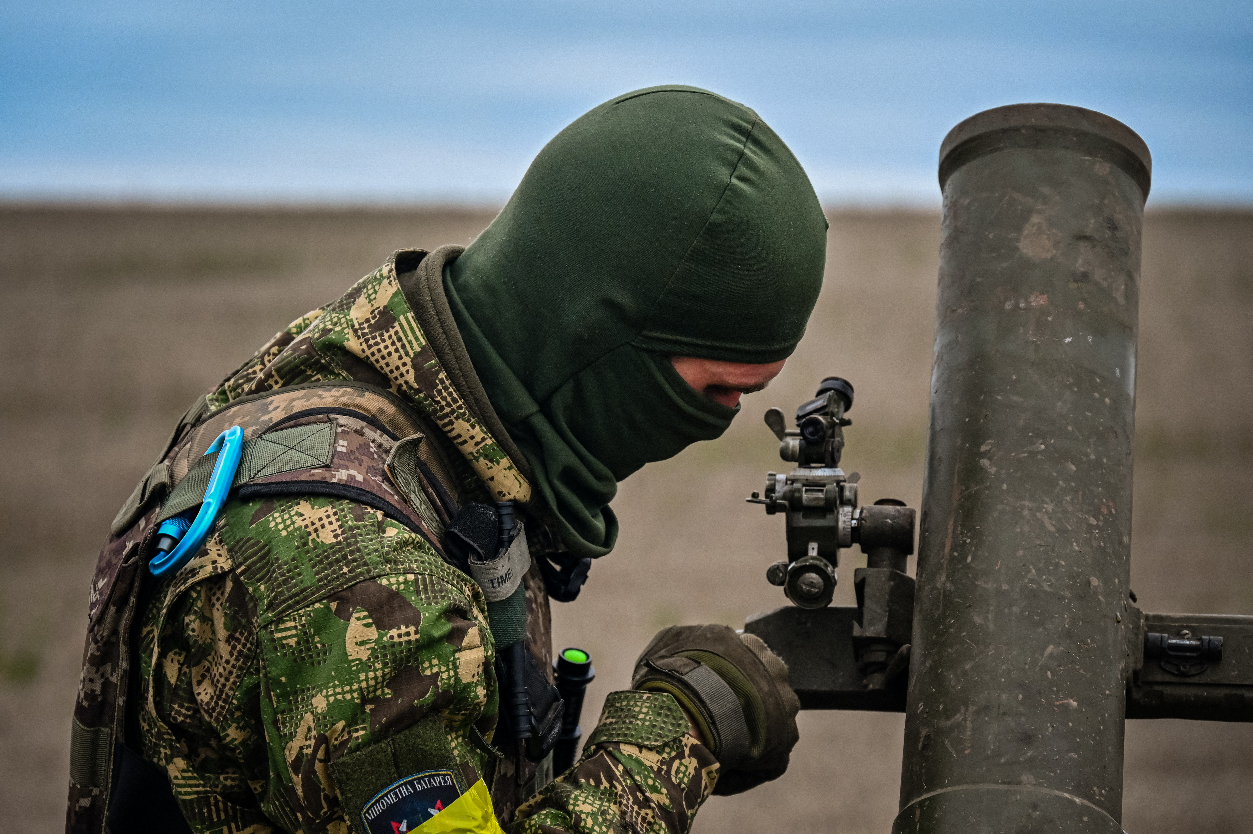 A member of Ukrainian National Guard adjusts a mortar launcher at a position along the front line in Kharkiv region on October 25, 2022, amid the Russian invasion of Ukraine. (Photo by SERGEY BOBOK / AFP)