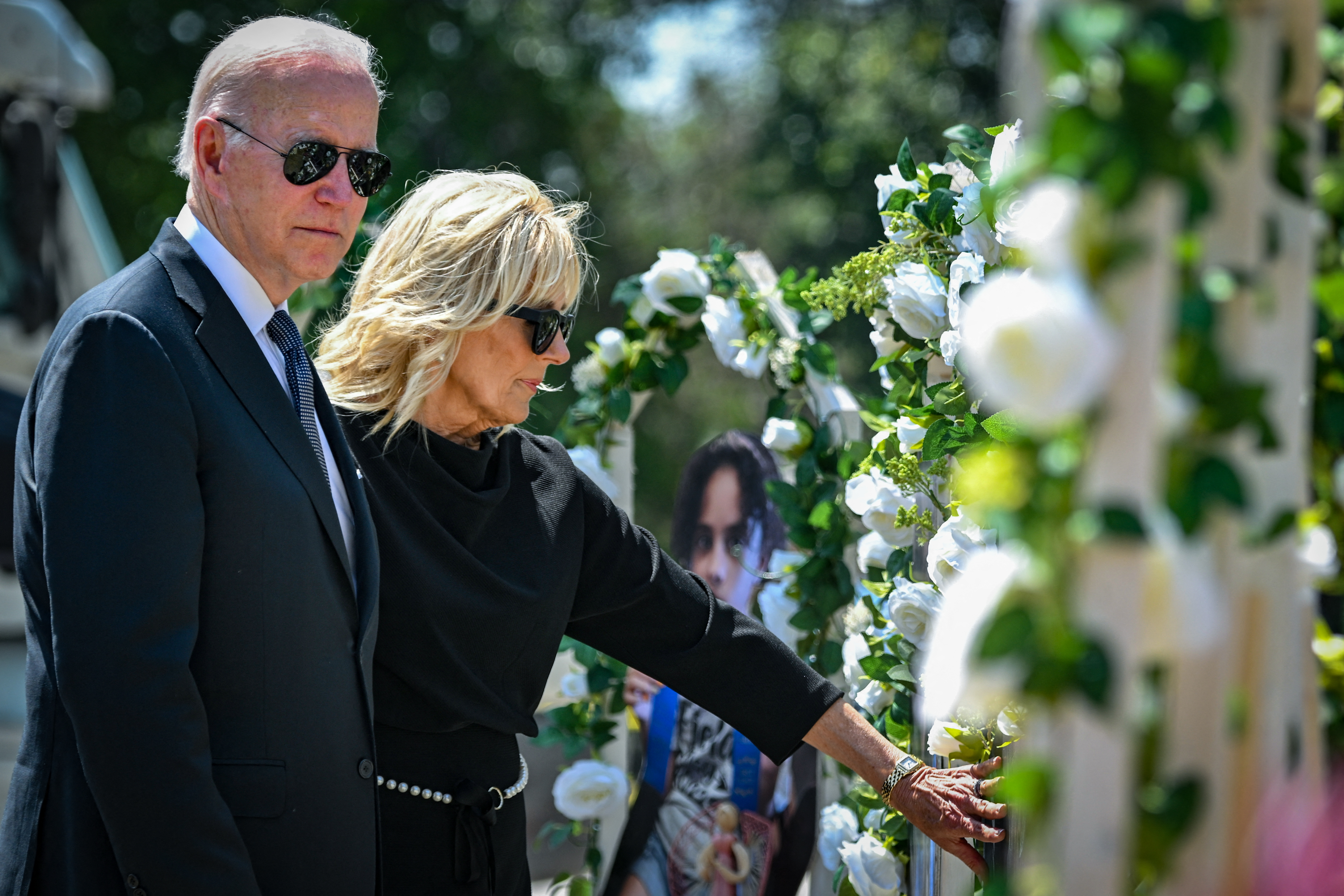 US President Joe Biden and First Lady Jill Biden pay their respects at a makeshift memorial outside of Robb Elementary School in Uvalde, Texas on May 29, 2022. - Biden is heading to Uvalde, Texas to pay his respects following a school shooting. (Photo by MANDEL NGAN / AFP)