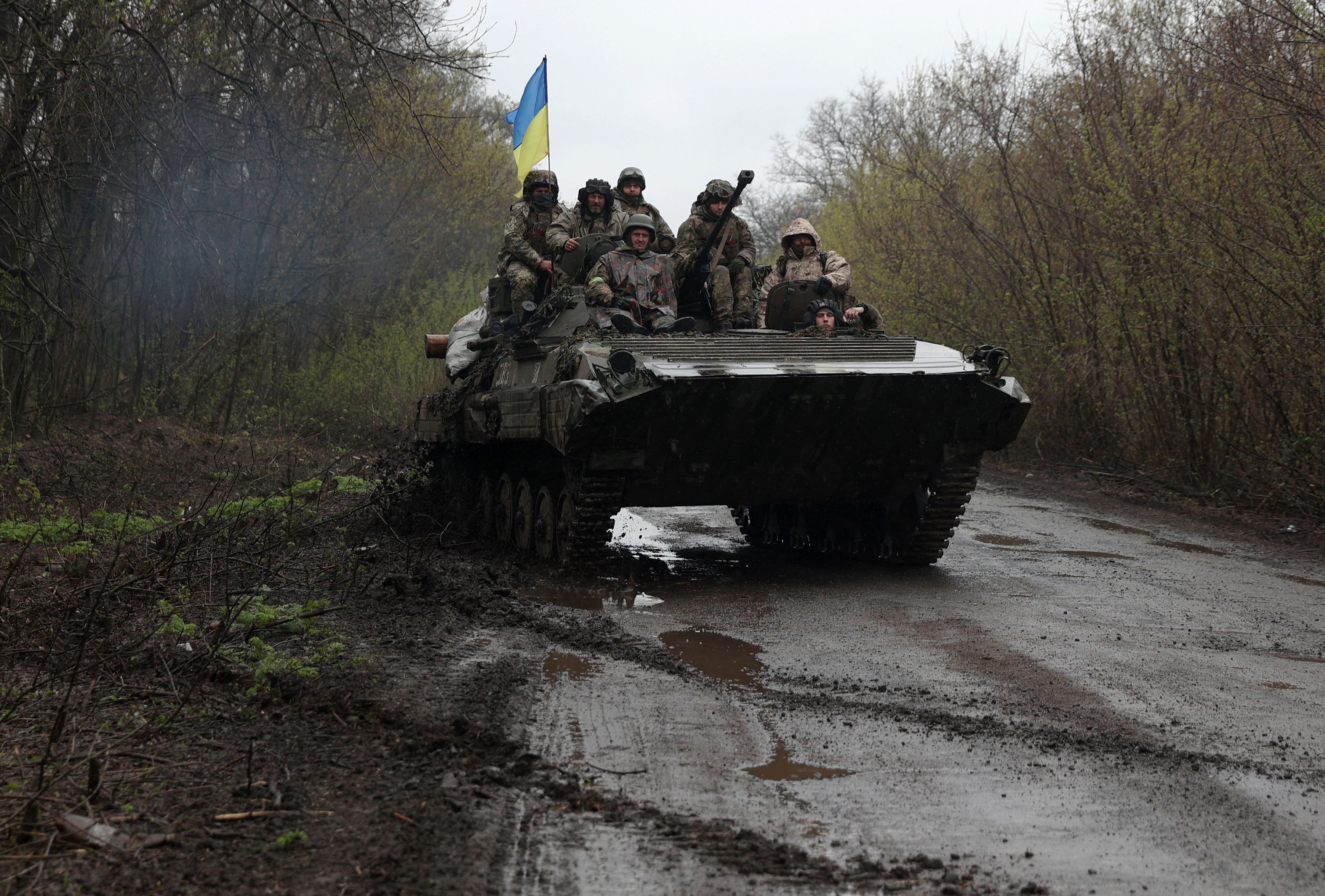 TOPSHOT - Ukrainian soldiers stand on an armoured personnel carrier (APC), not far from the front-line with Russian troops, in Izyum district, Kharkiv region on April 18, 2022, during the Russian invasion of Ukraine. (Photo by Anatolii Stepanov / AFP)