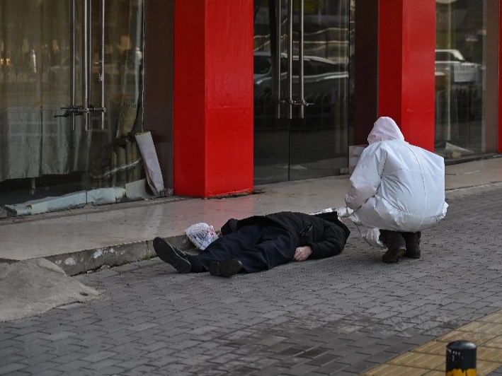 El cadaver de un hombre yace en medio de una calle en el centro de Wuhan, China, a finales de enero de 2020. Foto: Héctor Retamal / AFP