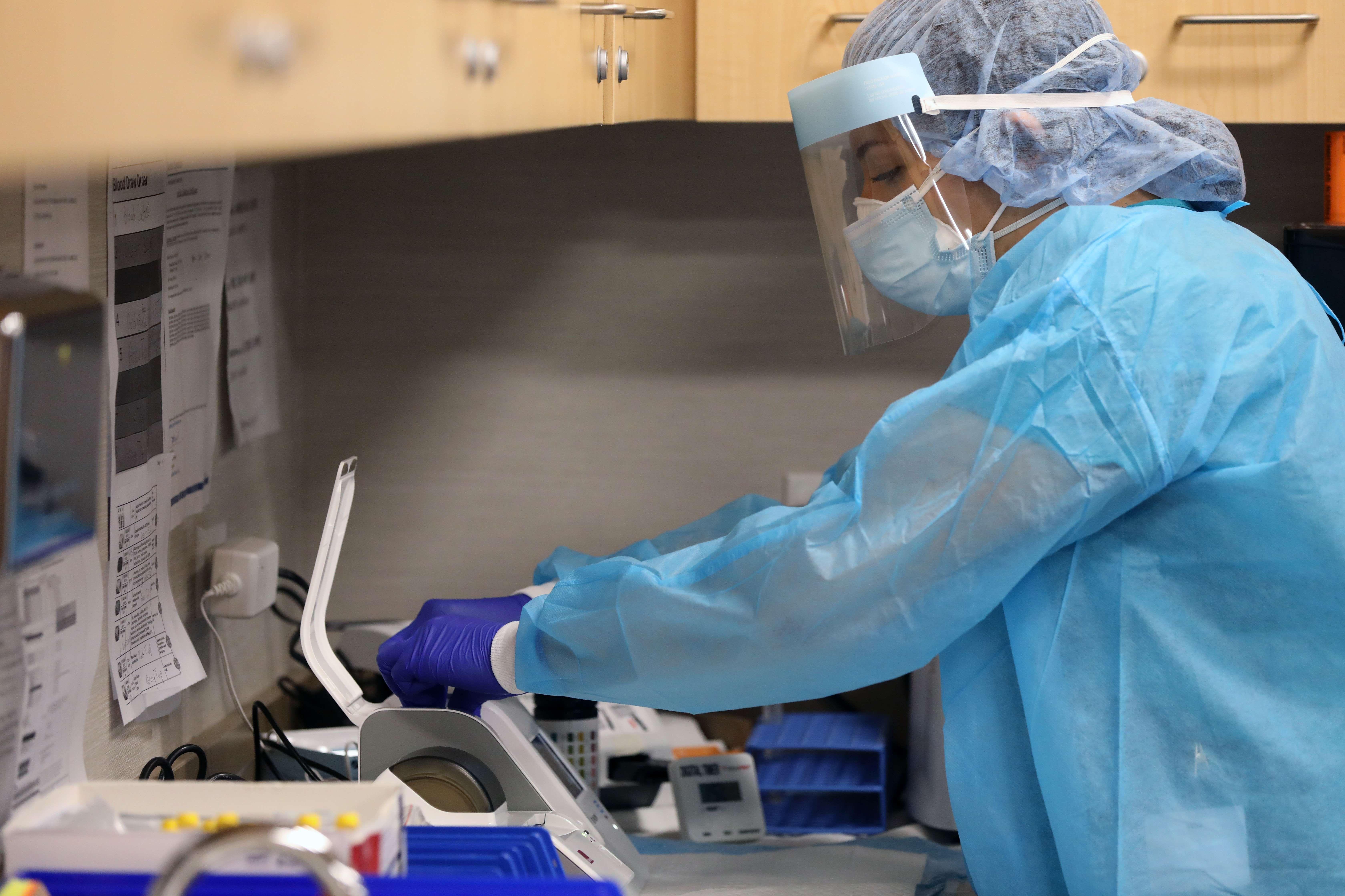 NEW YORK, NEW YORK - AUGUST 27: A medical worker shows the process for rapid coronavirus testing on the new Abbott ID Now machine at a ProHEALTH center in Brooklyn on August 27, 2020 in New York City. The portable Abbott ID Now uses a nasal swab to detect acute and infectious cases of COVID-19. ProHEALTH is offering the new service, which can deliver a test result in a s little as 15 minutes, at its centers in the tri-state area. Spencer Platt/Getty Images/AFP
== FOR NEWSPAPERS, INTERNET, TELCOS & TELEVISION USE ONLY ==