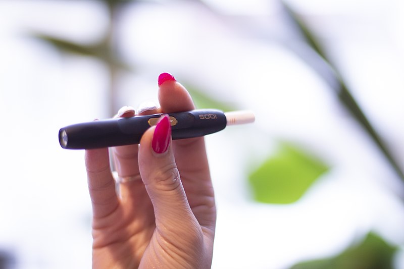 Este es el producto IQOS, de tabaco calentado que promociona la tabacalera Philip Morris. La Organización Mundial de la Salud, especialistas médicos e institutos de investigación advierten en que esta opción que promete reducir los daños del fumado esconde más riesgos de los que evidencia. Fotografía: Wikimedia Commons