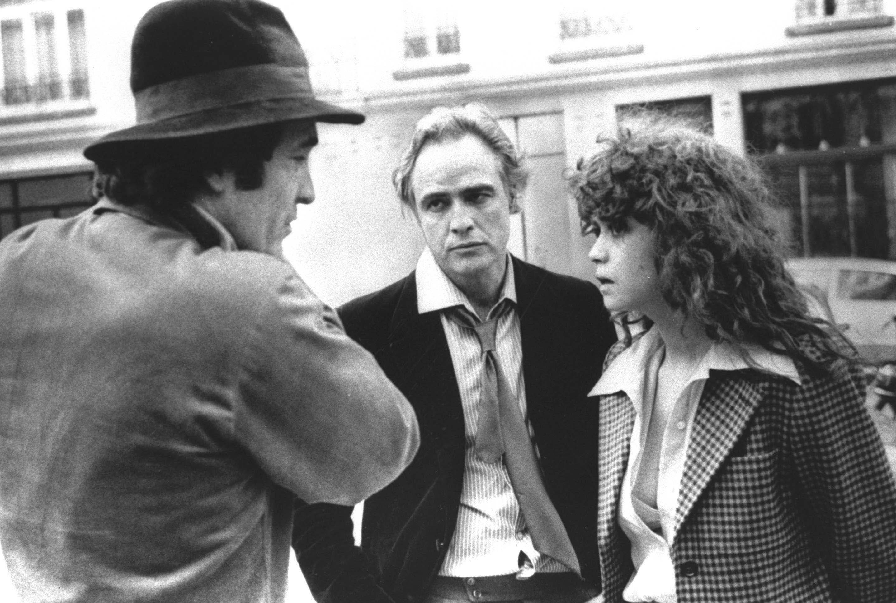 FILE -- Feb. 11, 1973 file photo Italian Director Bernardo Bertolucci, left, discusses a scene with leading actor Marlon Brando, center, and actress Maria Schneider during the shooting on the movie "Last Tango in Paris", in Paris, France. Bertolucci, who won Oscars with "The Last Emperor" and whose erotic drama "Last Tango in Paris" enthralled and shocked the world, has died at the age of 77. Bertolucci's press office, Punto e Virgola, confirmed the death Monday, Nov. 26, 2018, in an email to The Associated Press. (AP Photo)