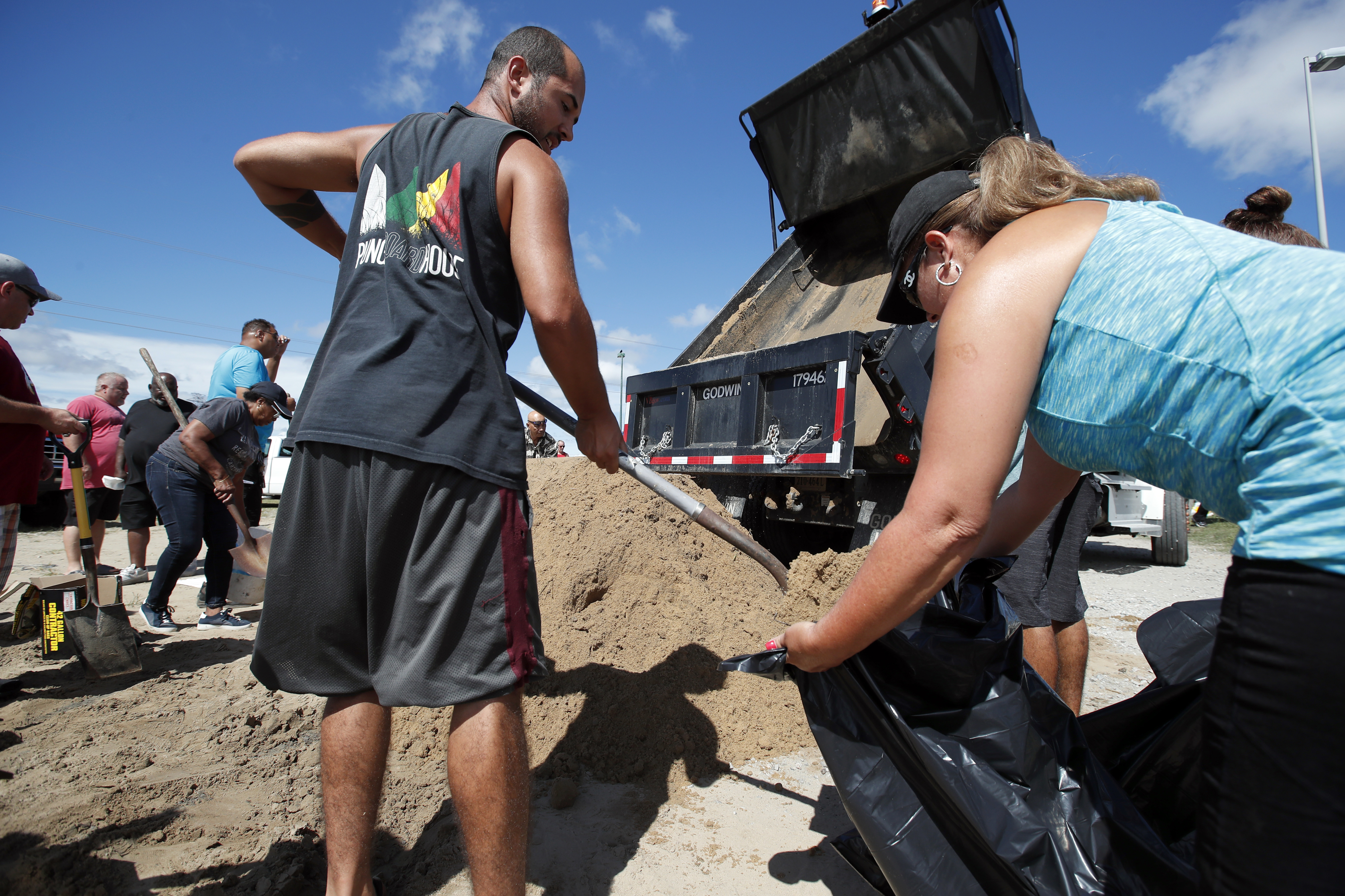 Giovanni Rivera (izquierda) y Nuvia Rivera llenan un saco de arena en Virginia Beach, Virginia, mientras el huracán Florence se mueve hacia la costa este, el 12 de setiembre del 2018. Foto: AP