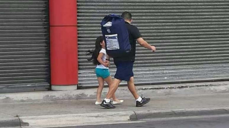 Padre con hija, él va cargando tula electoral