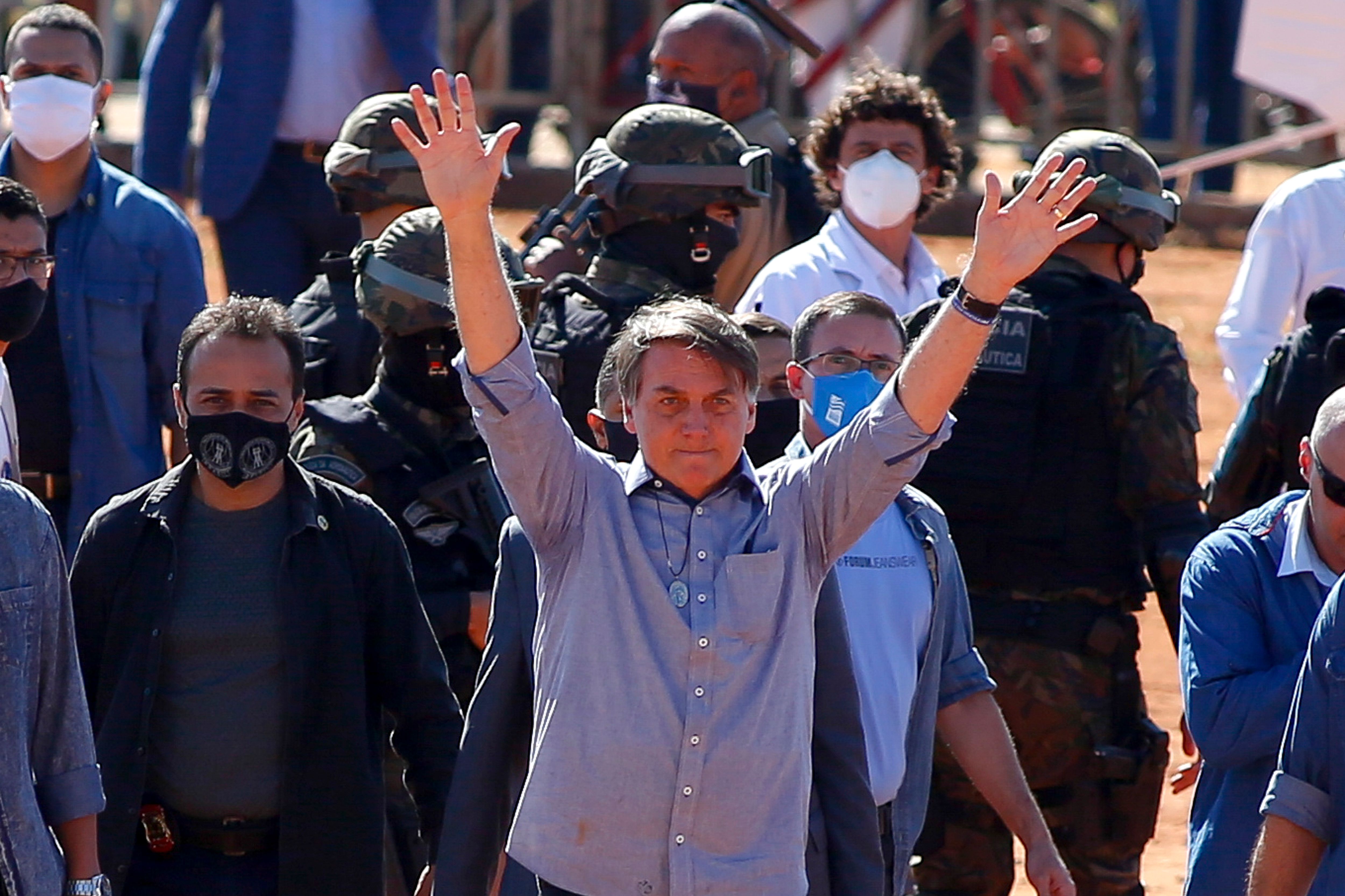 Brazilian President Jair Bolsonaro (C) waves to supporters during the inauguration of a field hospital in Aguas Lindas, in the State of Goiais, Brazil, on 05 June 2020, amid the Covid-19 coronavirus pandemic. (Photo by Sergio LIMA / AFP)