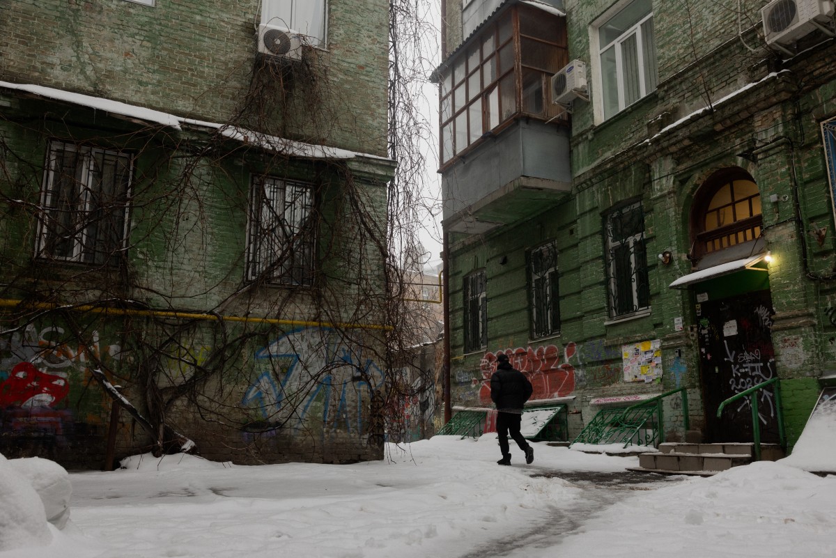 Un hombre camina junto a edificios residenciales en una calle cubierta de nieve en Kiev el 8 de enero de 2026, en medio de la invasión rusa de Ucrania.