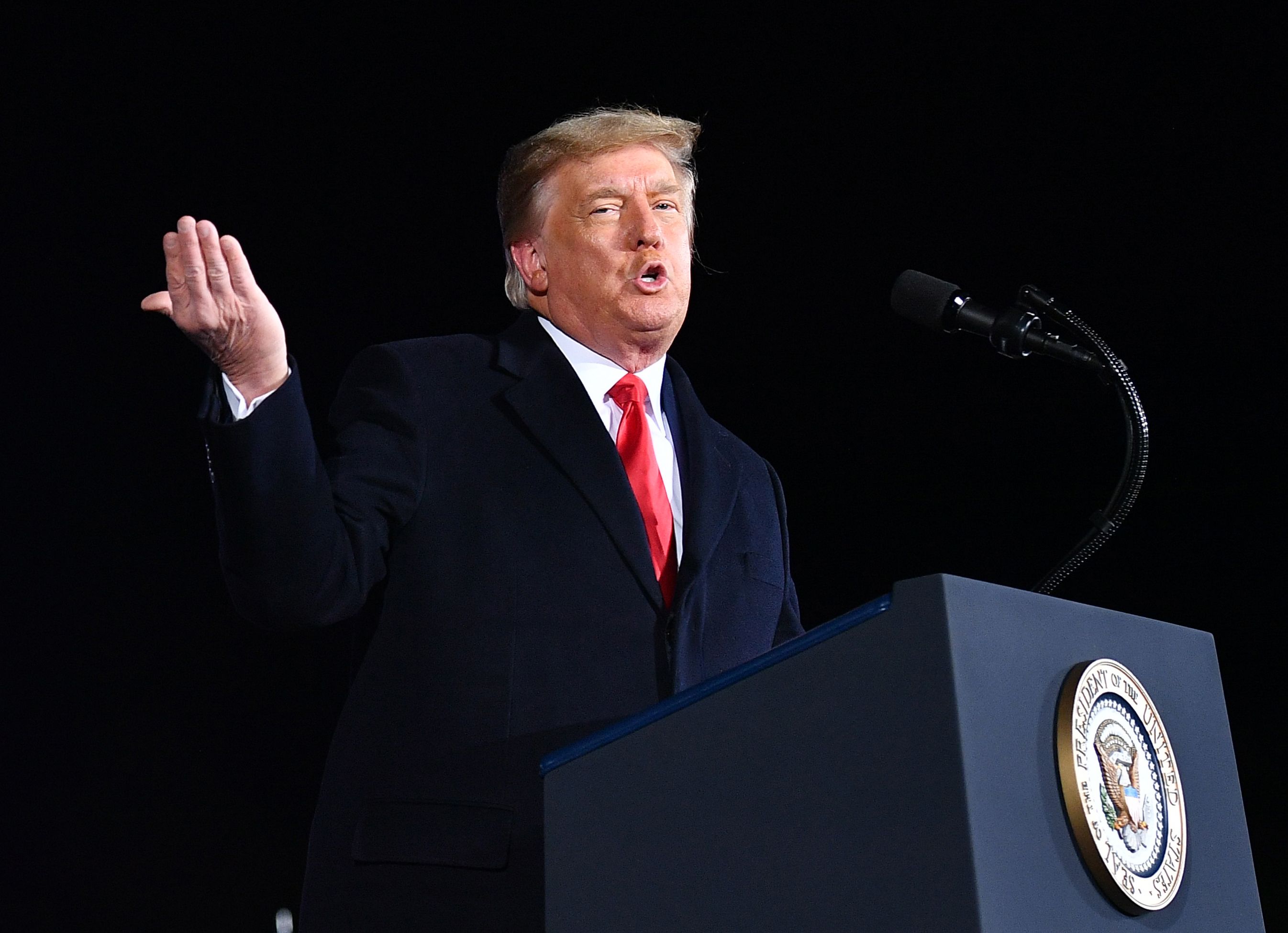 US President Donald Trump speaks during a rally in support of Republican incumbent senators Kelly Loeffler and David Perdue ahead of Senate runoff at Dalton Regional Airport, Georgia on January 4, 2021. - President Donald Trump, still seeking ways to reverse his election defeat, and President-elect Joe Biden converge on Georgia on Monday for dueling rallies on the eve of runoff votes that will decide control of the US Senate. Trump, a day after the release of a bombshell recording in which he pressures Georgia officials to overturn his November 3 election loss in the southern state, is to hold a rally in the northwest city of Dalton in support of Republican incumbent senators Kelly Loeffler and David Perdue. (Photo by MANDEL NGAN / AFP) / ALTERNATE CROP