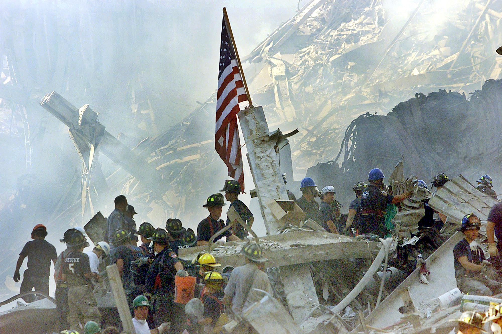 An American flag is posted in the rubble of the World Trade Centers 13 September 2001 in New York. The search for survivors and the recovery of the victims continues since the 11 September 2001 terrorist attack. AFP PHOTO/POOL/Beth A. KEISER (Photo by BETH A. KEISER / AP POOL / AFP)