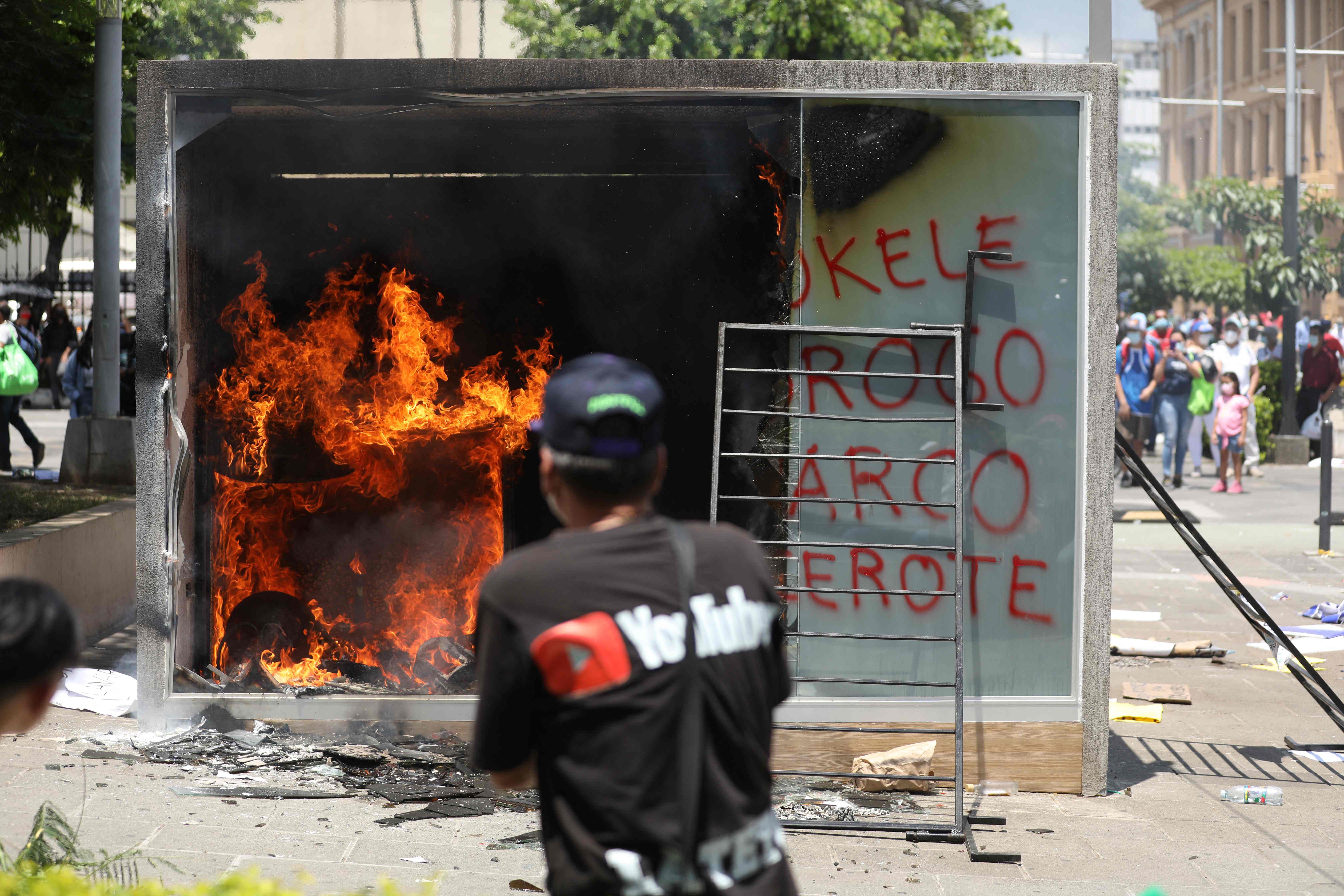 A Chivo Wallet Bitcoin ATM burns during a protest against President Nayib Bukele's policies on Independence Day in San Salvador, on September 15, 2021. - Thousands of Salvadorans demonstrated on Wednesday to demand that President Nayib Bukele respect the separation of powers and reject the introduction of bitcoin as legal tender, just as the country commemorates the bicentenary of its independence. (Photo by MARVIN RECINOS / AFP)