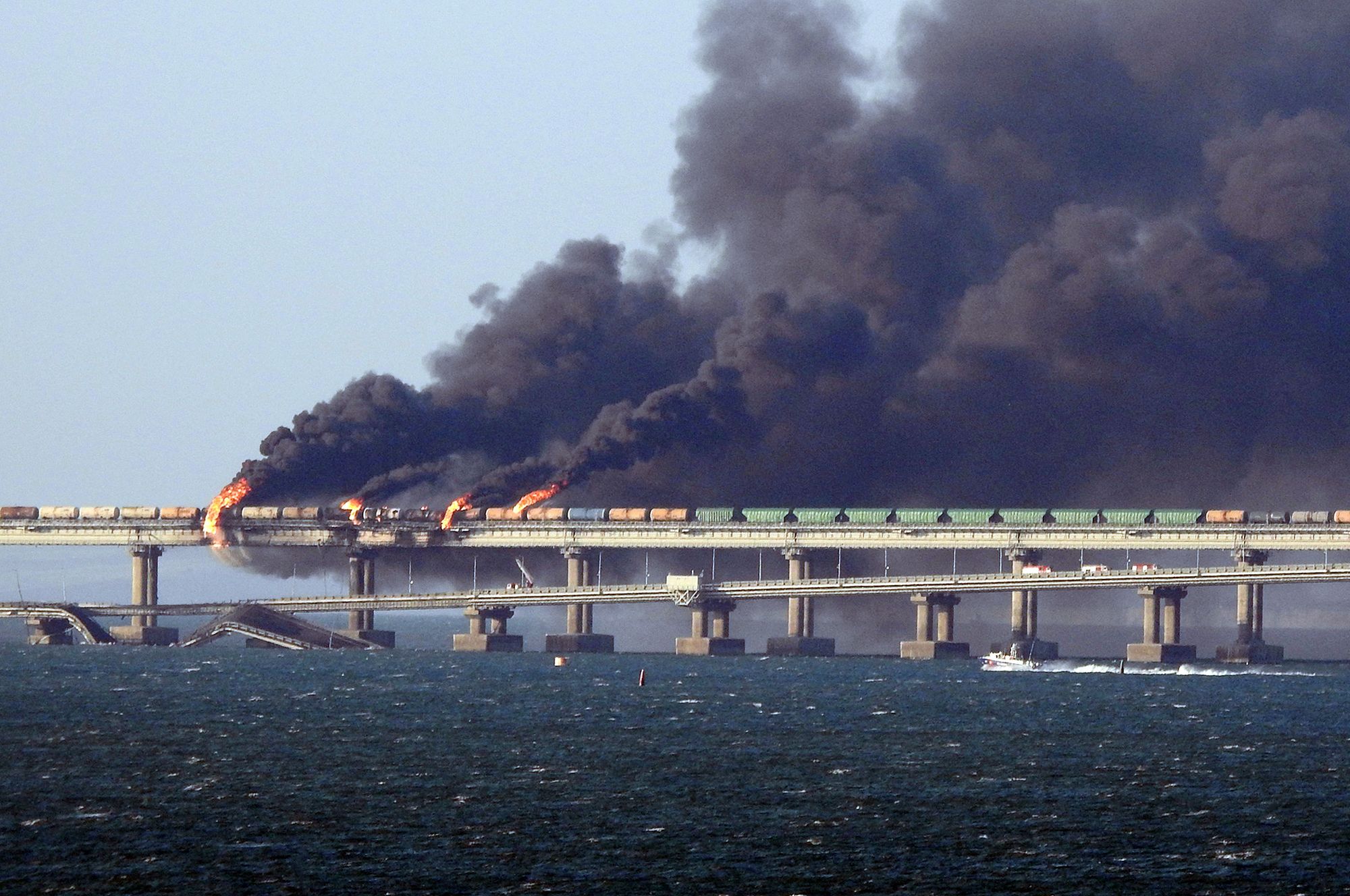 Black smoke billows from a fire on the Kerch bridge that links Crimea to Russia, near Kerch, on October 8, 2022. - Moscow announced on October 8, 2022 that a truck exploded igniting a huge fire and damaging the key Kerch bridge -- built as Russia's sole land link with annexed Crimea -- and vowed to find the perpetrators, without immediately blaming Ukraine. (Photo by AFP)