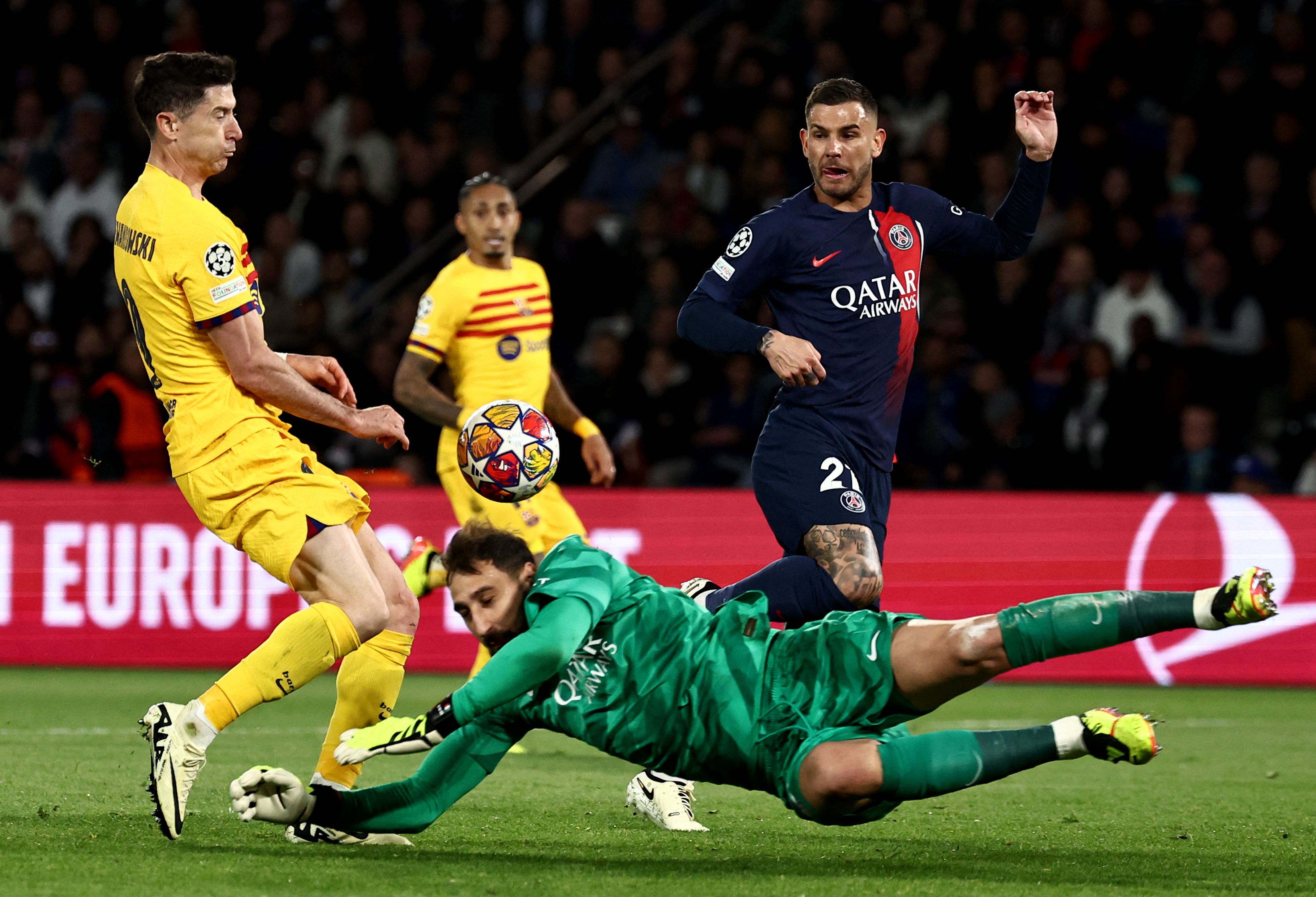 Barcelona's Polish forward #09 Robert Lewandowski (L) and Paris Saint-Germain's Italian goalkeeper #99 Gianluigi Donnarumma (C) fight for the ball during the UEFA Champions League quarter final first leg football match between Paris Saint-Germain (PSG) and FC Barcelona at the Parc des Princes stadium in Paris on April 10, 2024. (Photo by Anne-Christine POUJOULAT / AFP)