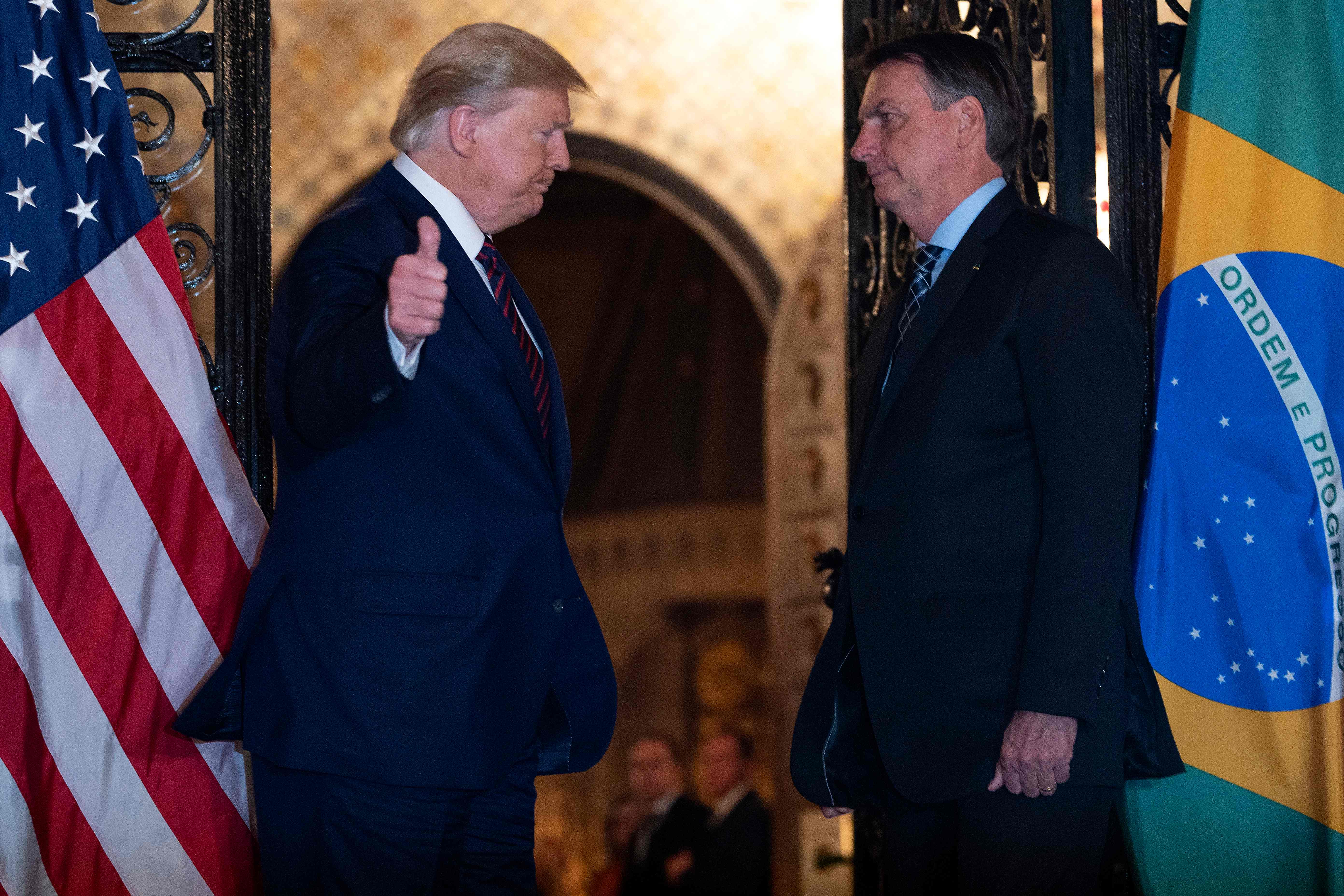 (FILES) In this file photo US President Donald Trump (L) speaks with Brazilian President Jair Bolsonaro during a dinner at Mar-a-Lago in Palm Beach, Florida, on March 7, 2020. - Brazilian President Jair Bolsonaro said on March 12 he will know "in the next few hours" if he has contracted the new coronavirus after a top aide tested positive for the disease following a trip on which both met with US President Donald Trump. (Photo by JIM WATSON / AFP)