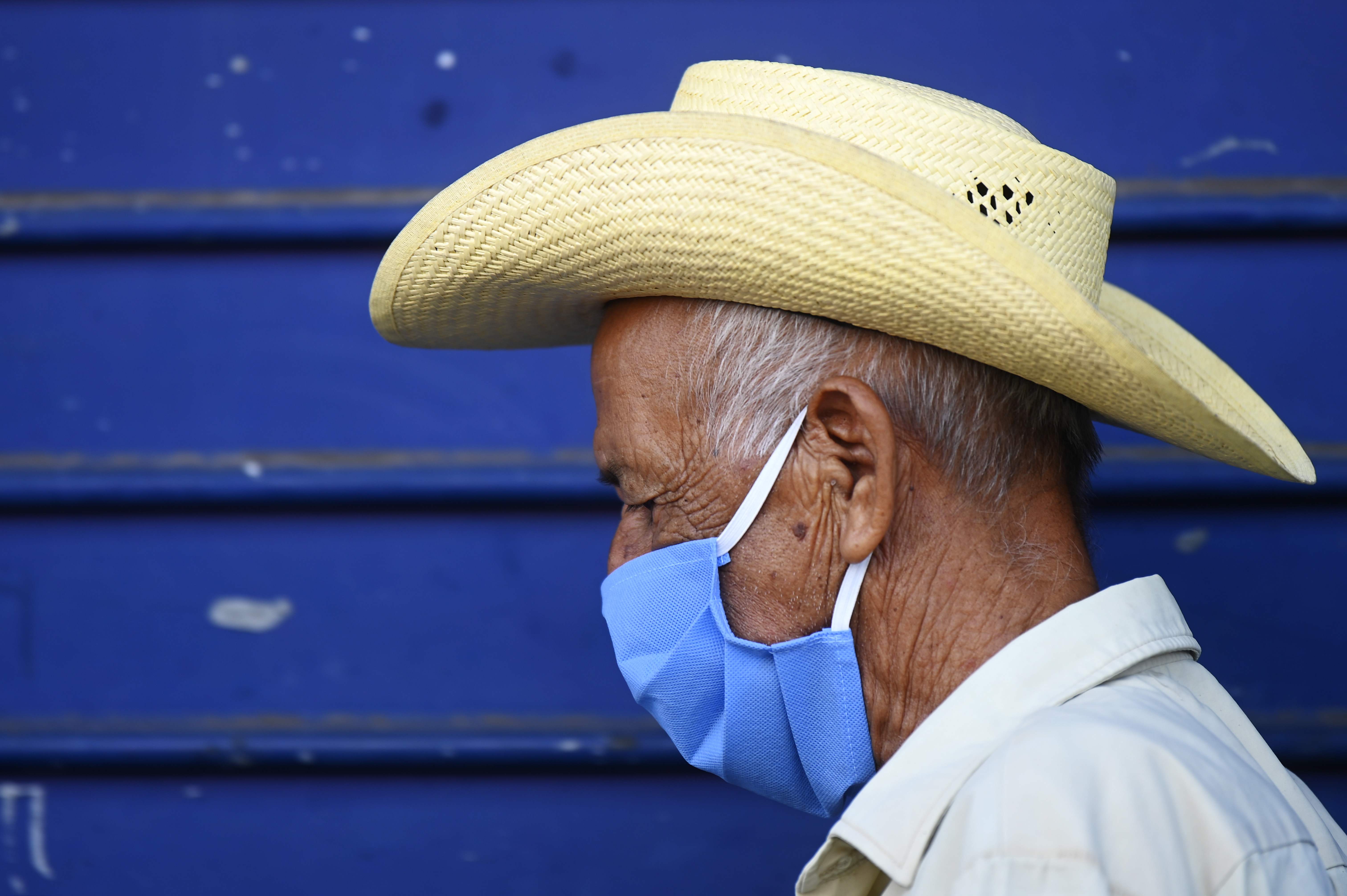 A pensioner queues outside a bank wearing face mask as a preventive measure against the spread of the COVID-19 coronaavirus in San Salvador, on March 25, 2020. (Photo by MARVIN RECINOS / AFP)