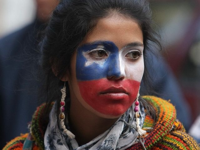 SCH216- SANTIAGO (CHILE), 06/10/2011. Una joven con el rostro pintado con la bandera de Chile, camina junto a estudiantes de secundaria de la región del Biobío, que iniciaron una caminata el 25 de septiembre pasado desde esa zona a 515 kilómetros de Santiago, hoy jueves 6 de octubre de 2011. Una marcha estudiantil no autorizada derivó hoy en violentos disturbios en el centro de la capital chilena, un día después de la ruptura del diálogo entre los estudiantes y el Gobierno para saldar un conflicto de casi cinco meses. EFE/Mario Ruiz
