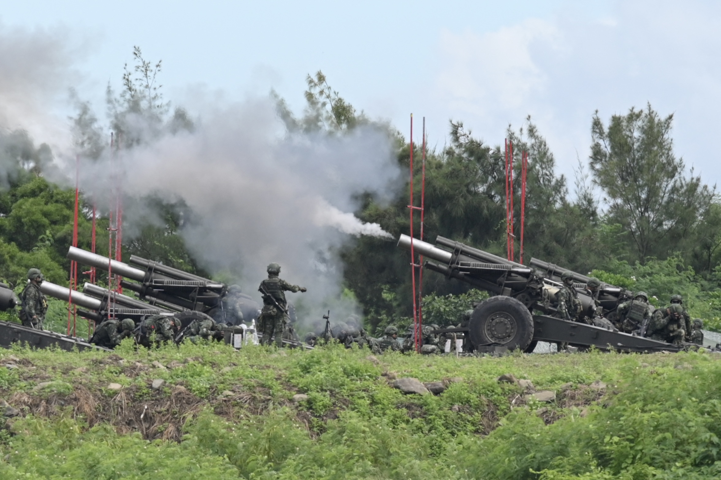 Taiwan military soldiers fire the 155-inch howitzers during a live fire anti landing drill in the Pingtung county, southern Taiwan on August 9, 2022. (Photo by Sam Yeh / AFP)