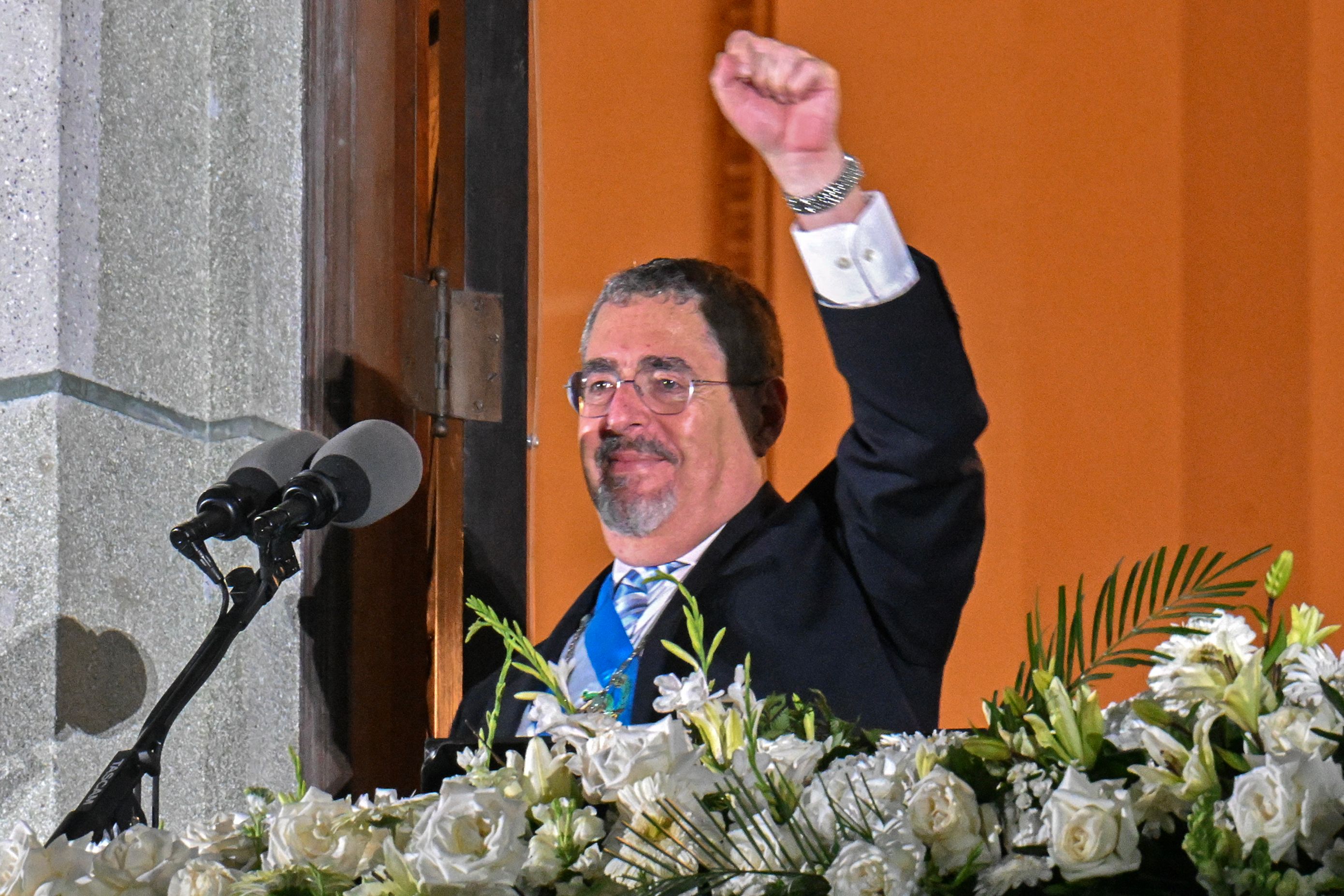Guatemala's new President Bernardo Arevalo gestures at supporters from a balcony of the Miguel Angel Asturias Cultural Centre in Guatemala City, after the inauguration ceremony, early on January 15, 2024. Bernardo Arevalo was finally sworn in as Guatemala's president on early Monday after the ceremony was delayed for more than nine hours, capping months of judicial machinations to block the anti-corruption crusader from taking office. (Photo by JOHAN ORDONEZ / AFP)