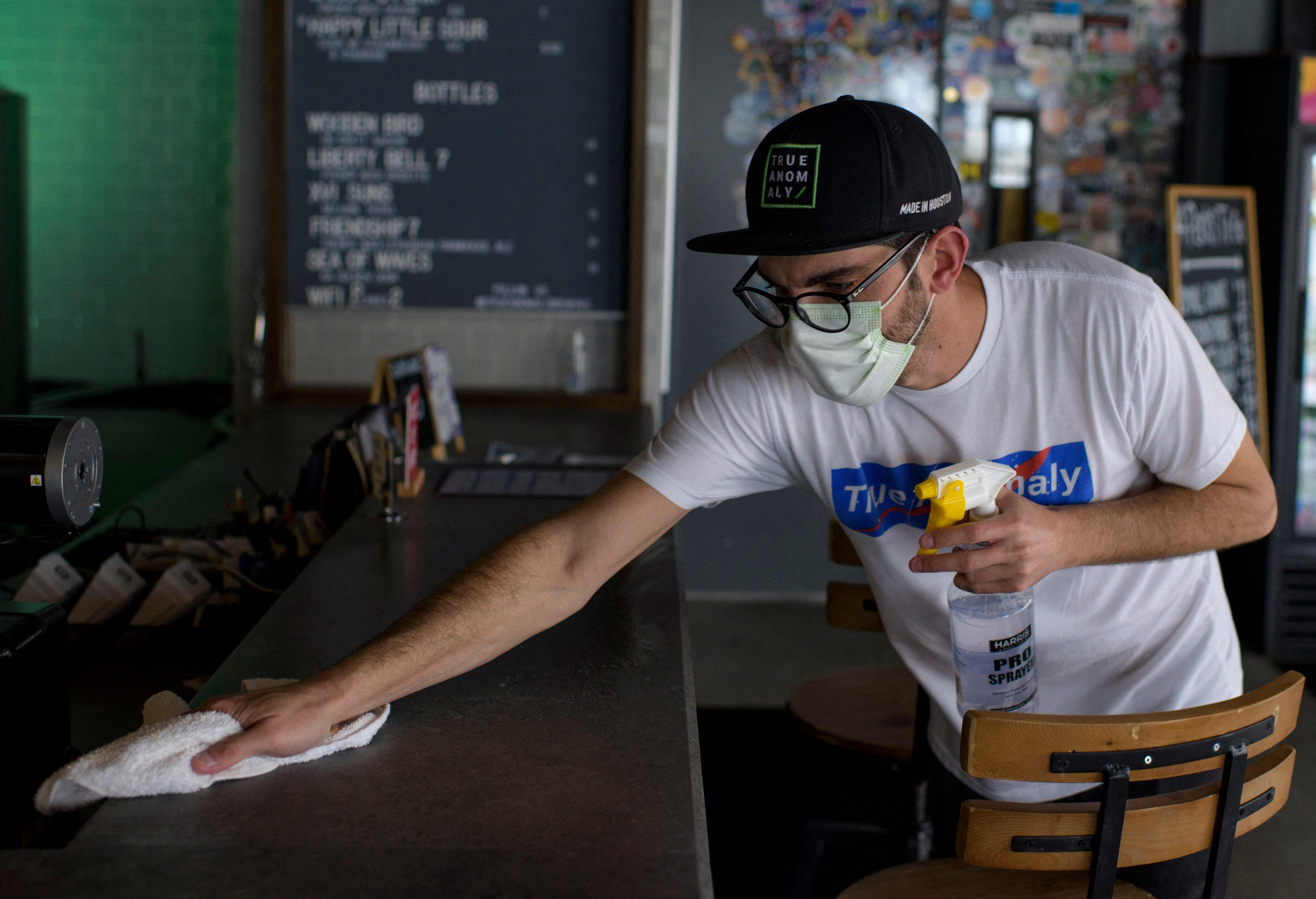 (FILES) In this file photo taken on March 10, 2021, Spencer Church cleans at True Anomaly Brewing Co. in Houston, Texas. - Covid cases are declining quickly while vaccinations continue to rise slowly but surely in the US, the former epicenter of the pandemic. Many experts believe the time will soon be right for the federal government to ease its recommendations on indoor masking across the board, and say doing so could help encourage more vaccine holdouts about the clear benefits of getting their shots. (Photo by Mark Felix / AFP)